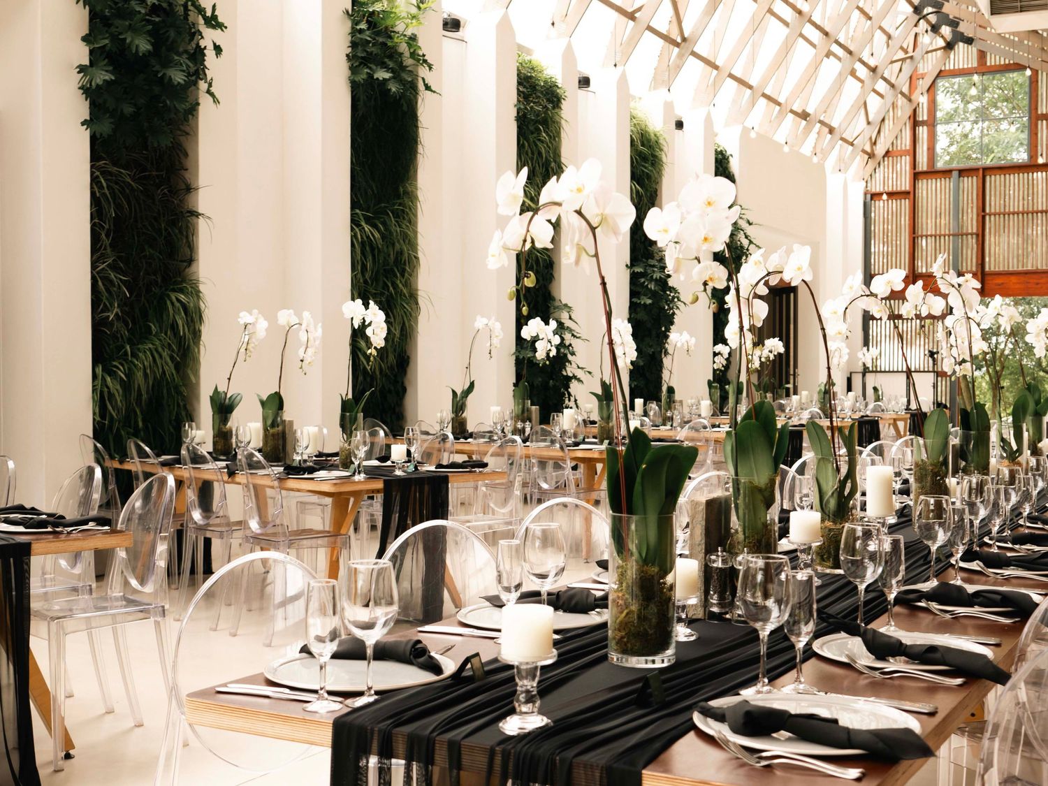 Elegant wedding reception table setting with black accents and greenery