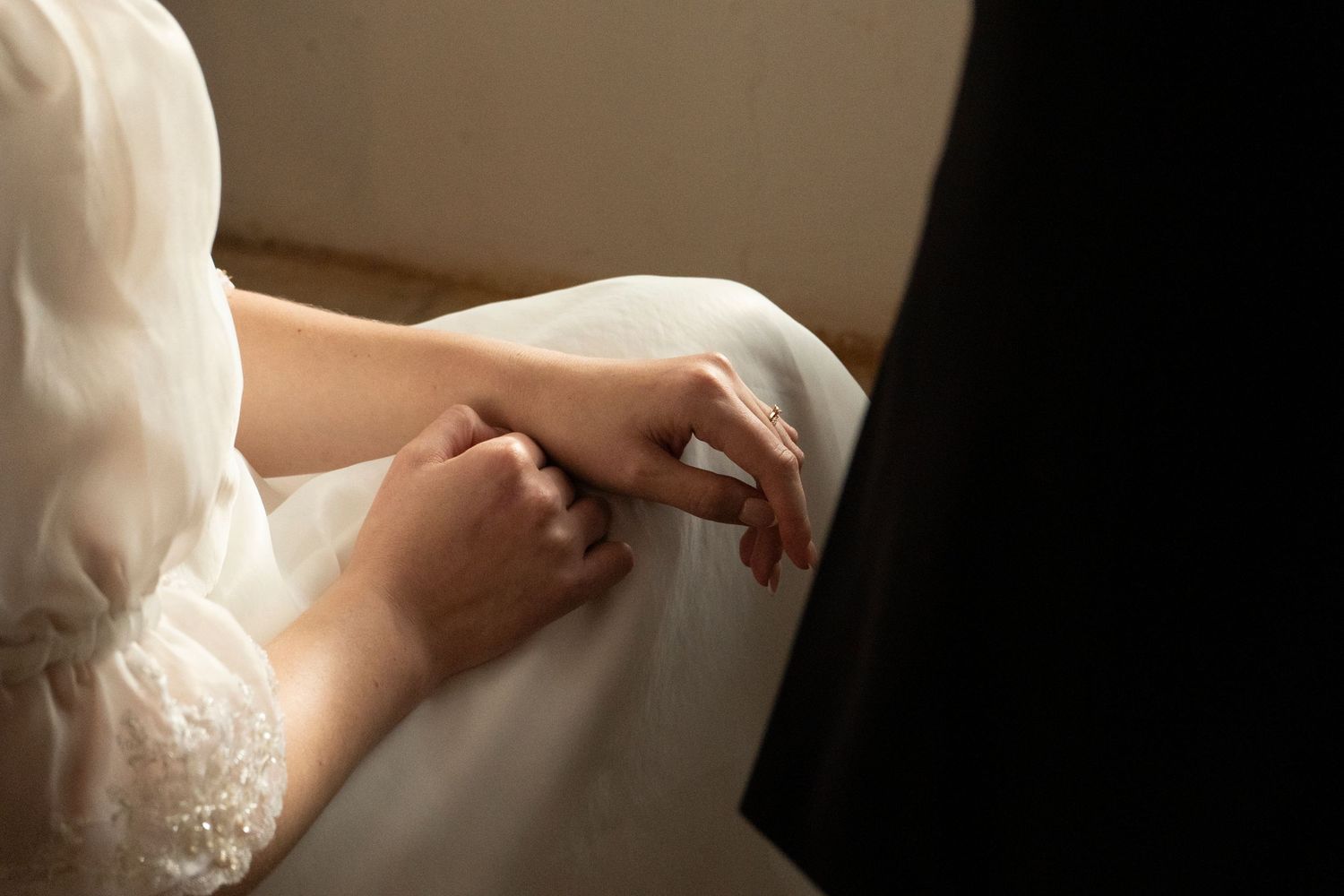 Close-up of the bride's hand resting on a dark surface while getting ready