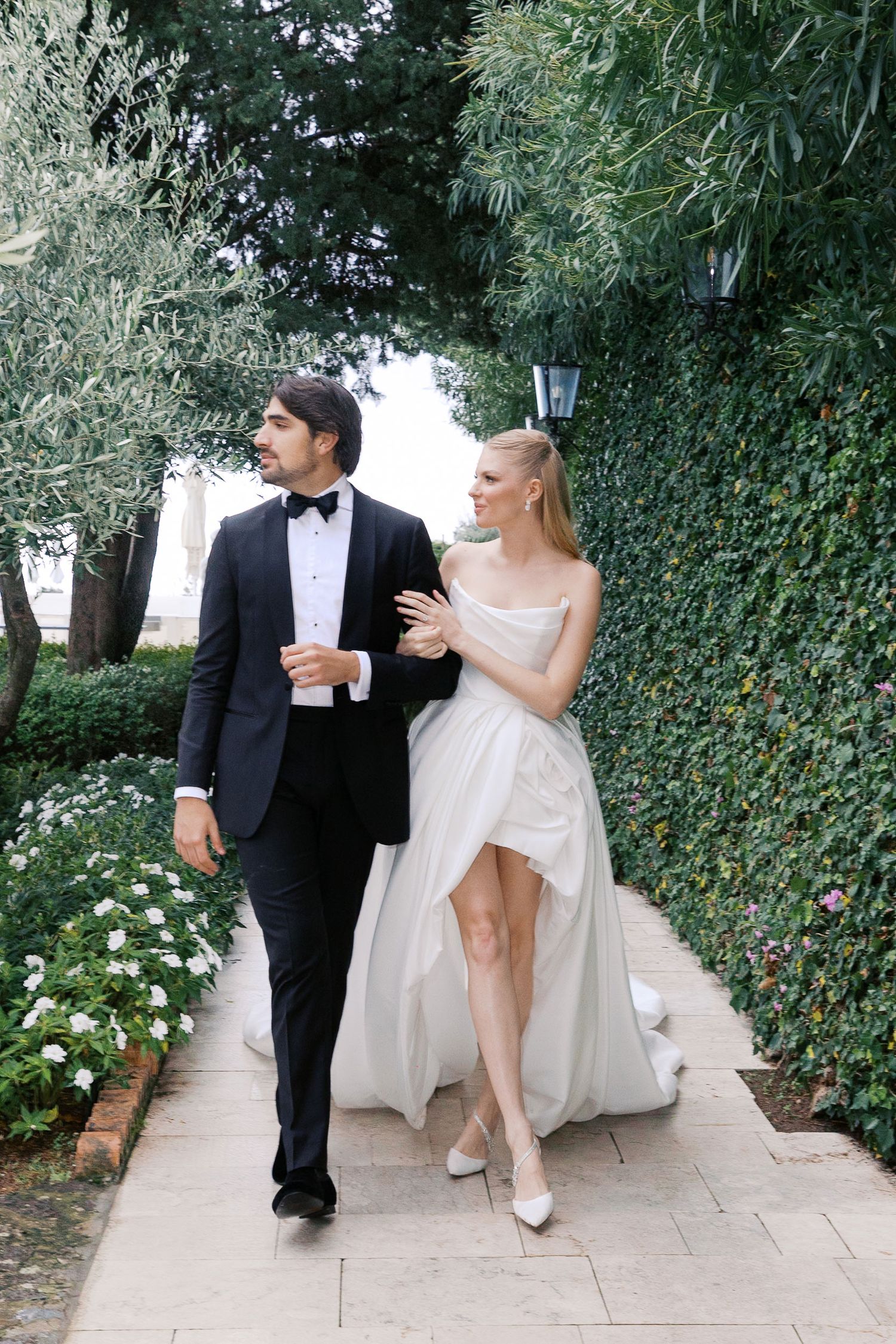 A sequence of playful wedding photos showing a couple in formal attire posing along a garden pathway at Villa Rondinaia, Ravello Italy.