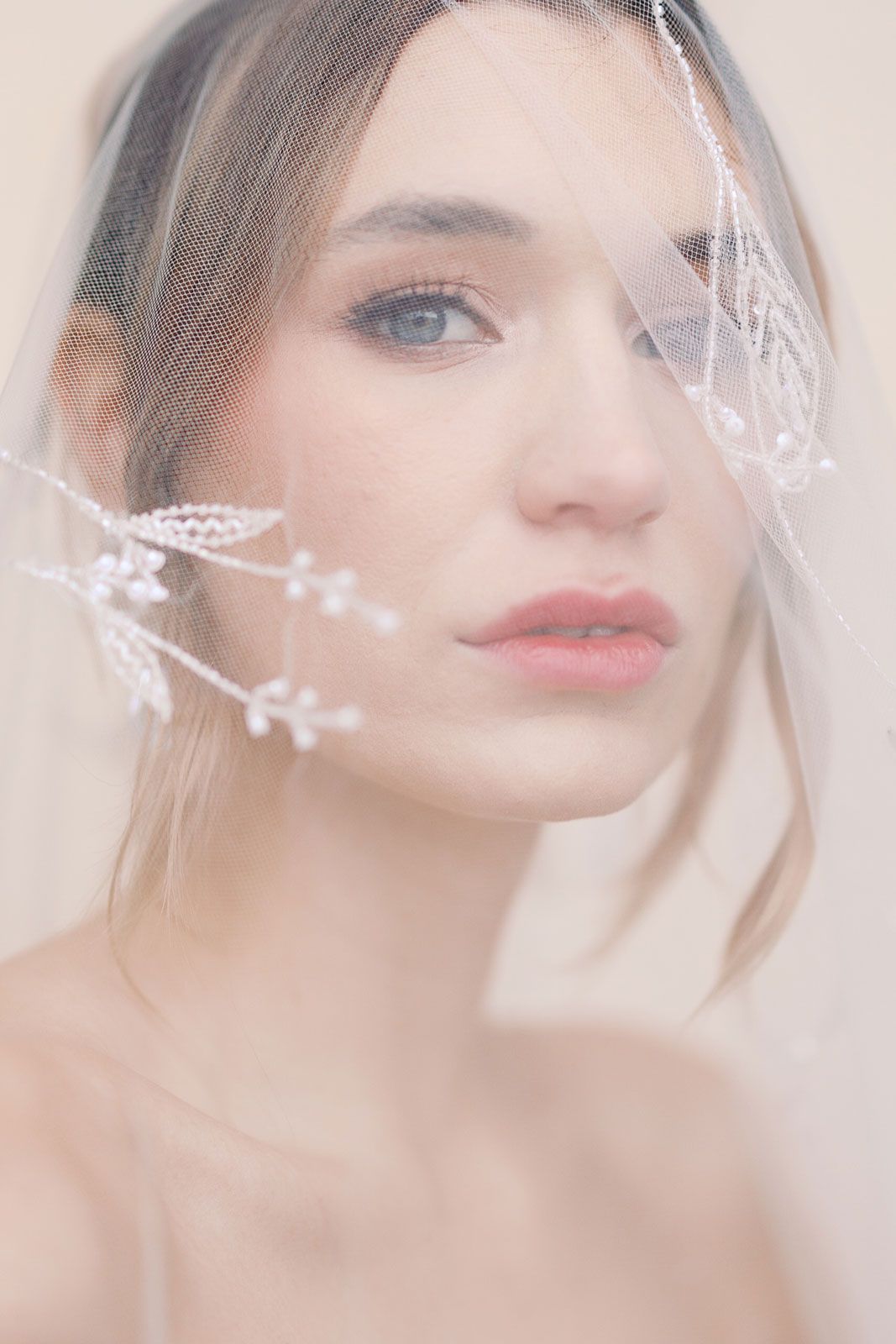 Ethereal bridal portraits with delicate veil details in soft, dreamy lighting.