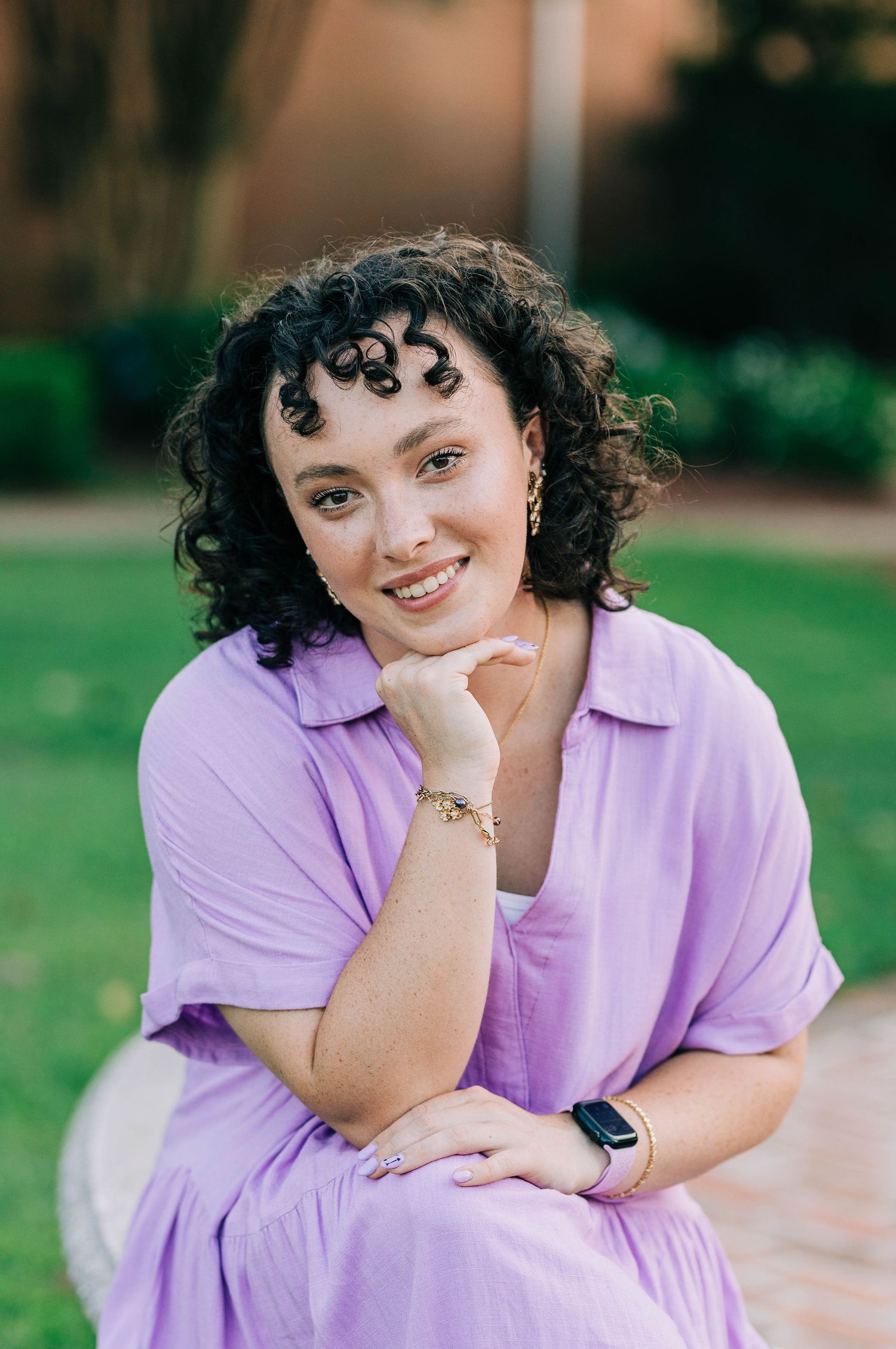 Person in purple shirt poses casually outdoors with natural lighting.