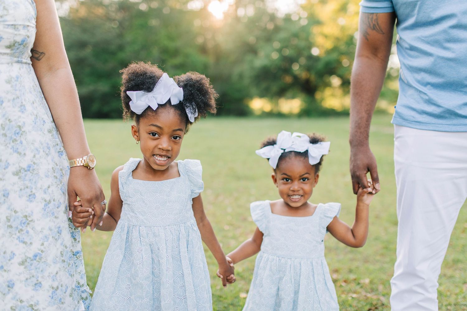 Family members in matching blue and white outfits hold hands while walking.
