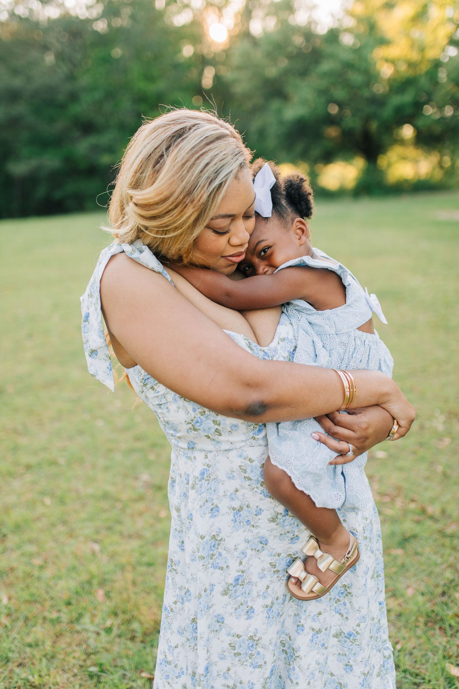 Sweet candid moments between parent and child in matching outfits during golden hour photoshoot.