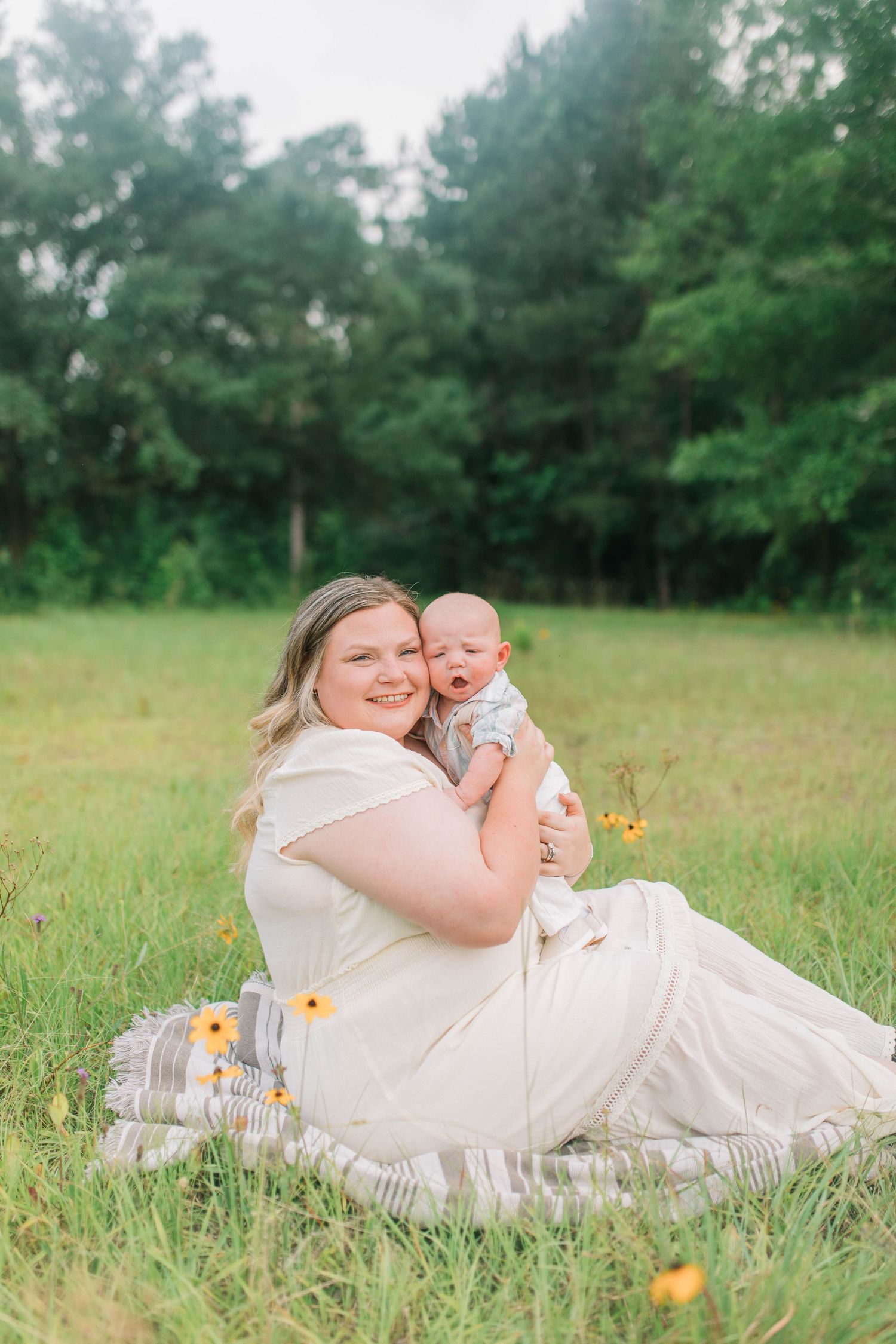 Sweet moments shared while resting in tall grass during outdoor photo session.