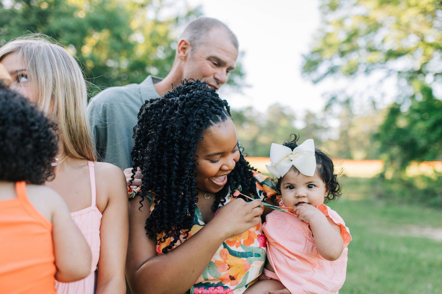 Joyful outdoor photoshoot featuring colorful summer dresses and natural interactions.