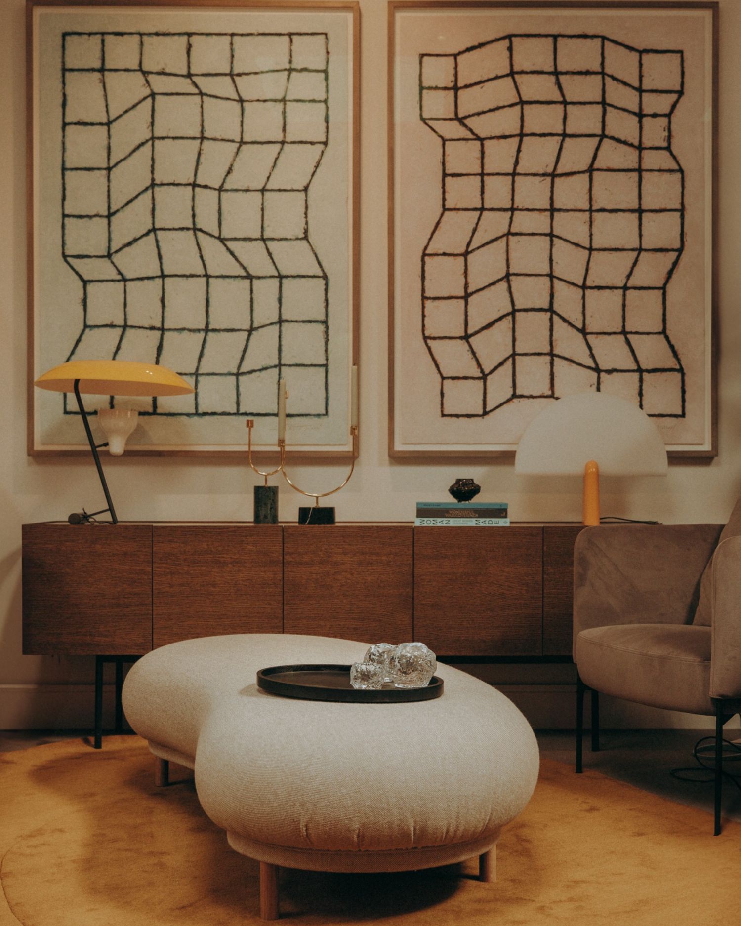 Lounge with soft pouffe, abstract art, and a sculptural table — styled interior captured in Dublin by Sigi Photography.