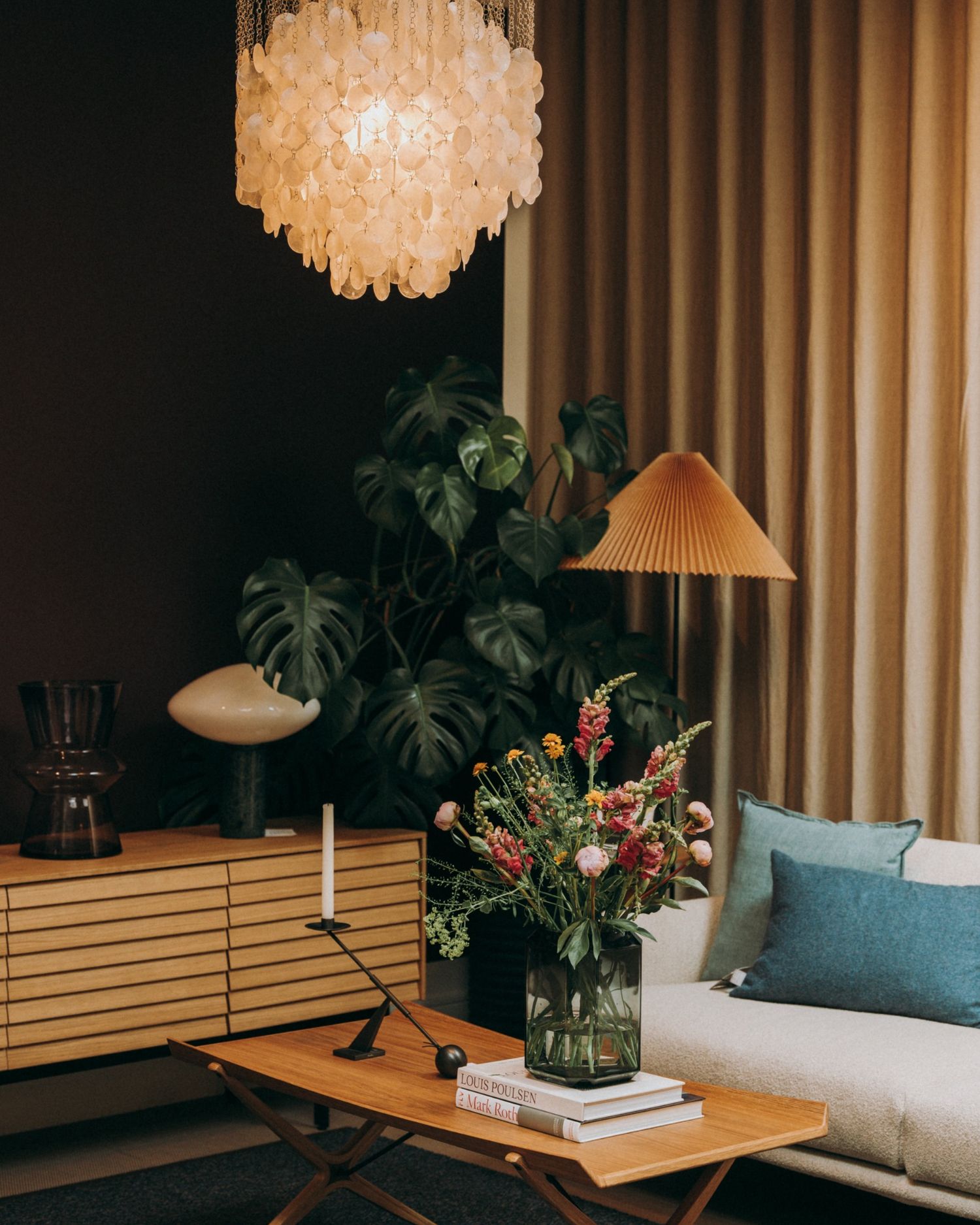 Nordic lounge with a shell chandelier, books, monstera, and flowers — styled and photographed in Dublin by Sigi.
