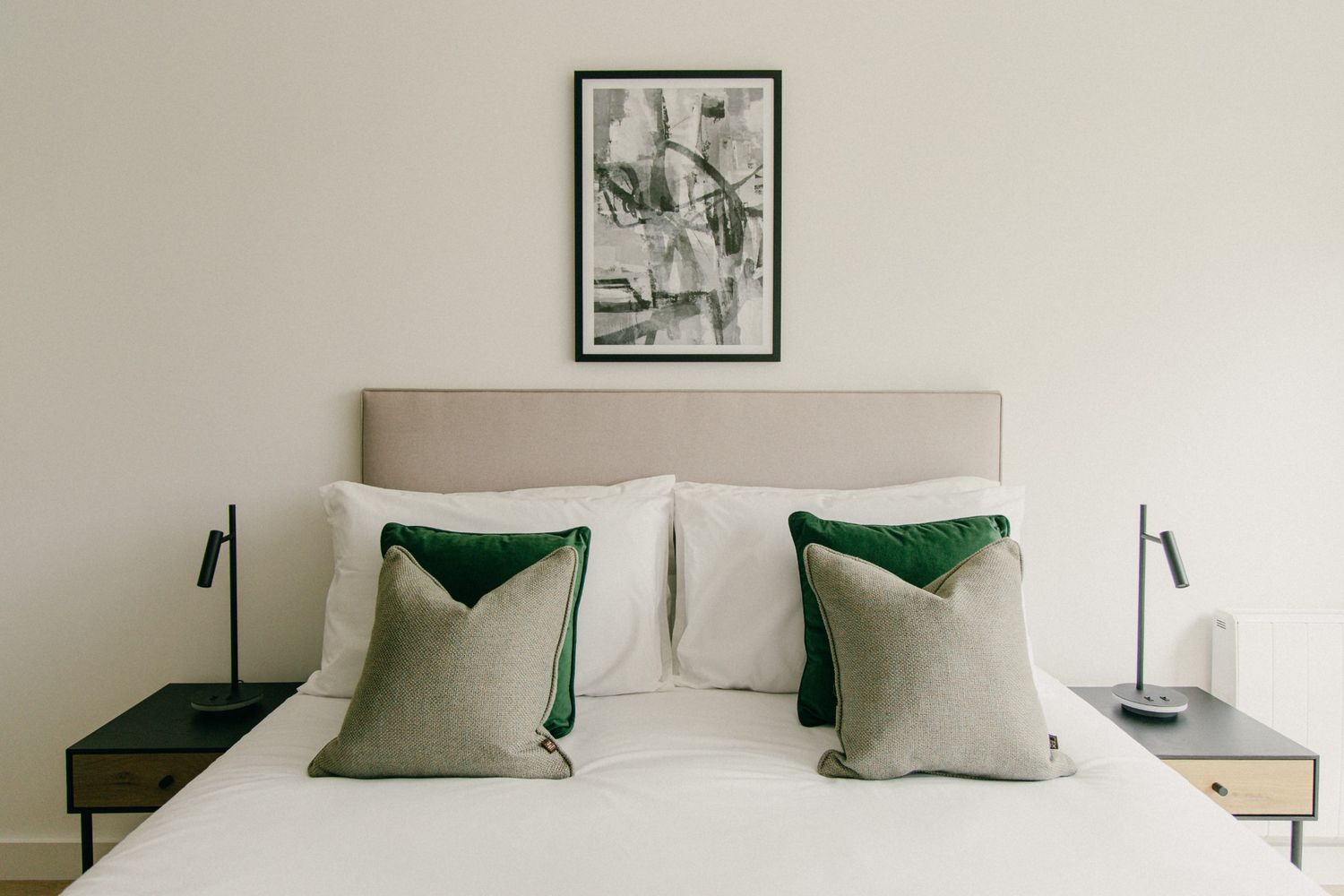 Minimal bedroom with neutral palette, green velvet pillows, and soft natural light — perfect for Airbnb or property styling in Dublin