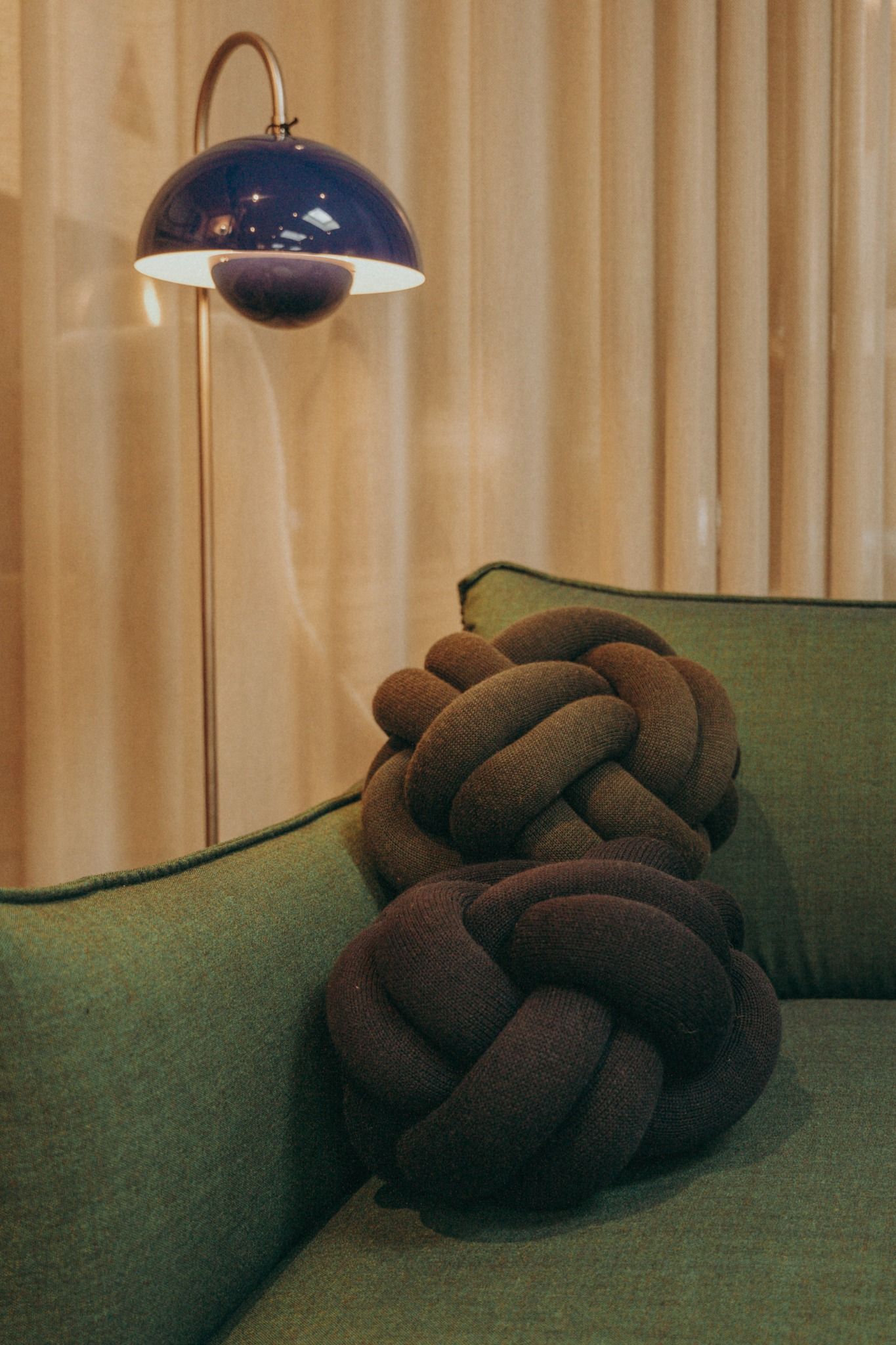 Stylish blue dome floor lamp beside a green sofa with knot cushions — cosy modern decor by Sigi Photography, Dublin.