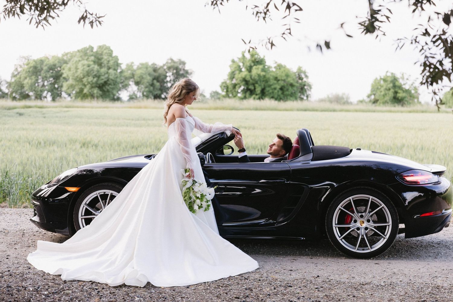 Wedding photography session featuring a bride and black convertible sports car.