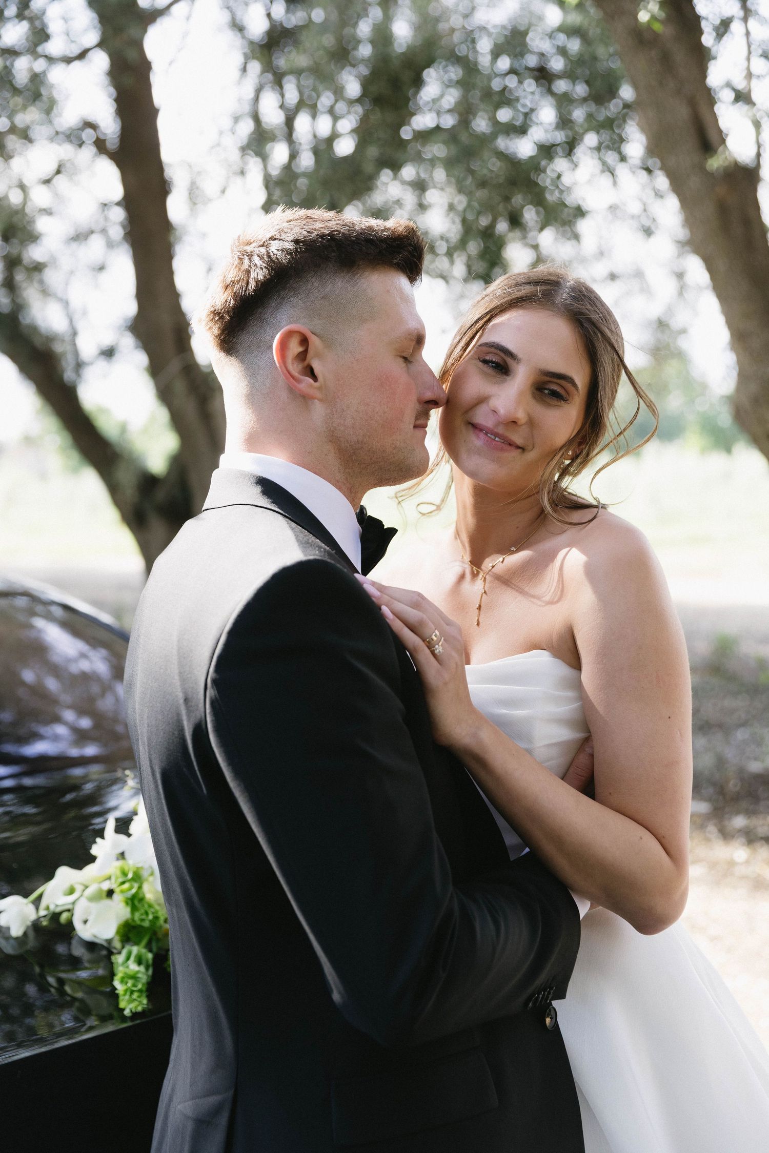Intimate wedding portraits captured in natural lighting under a grove of trees.