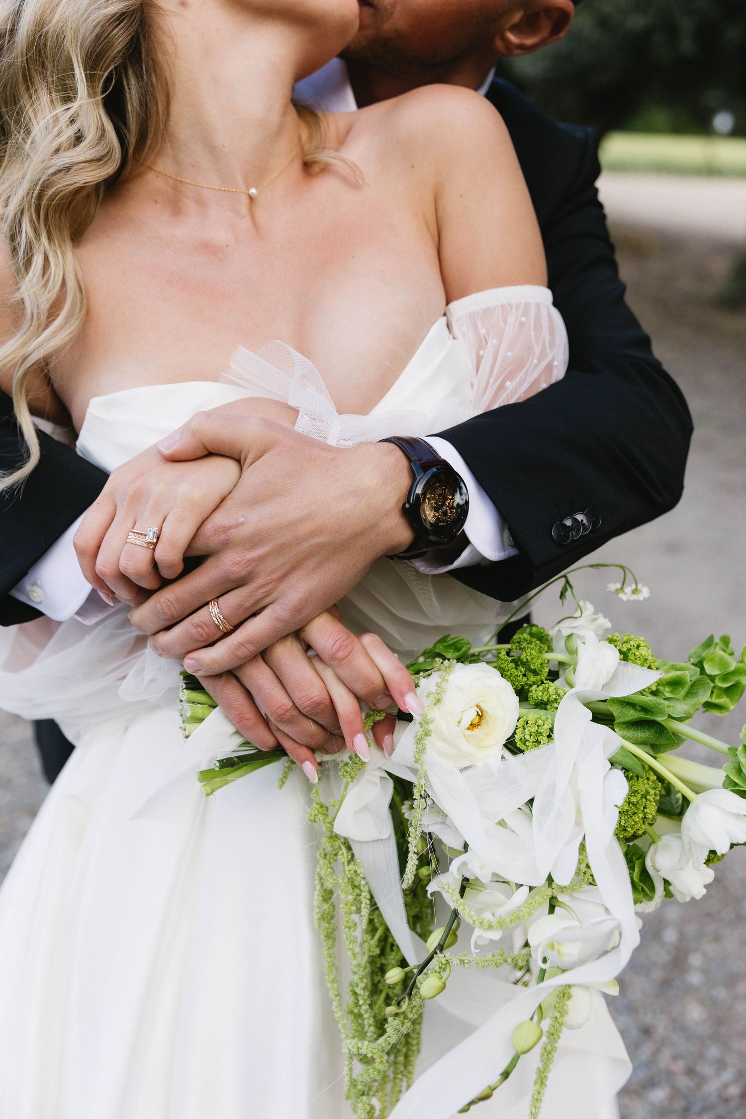 Intimate wedding portrait showing rings, bouquet and dress details.
