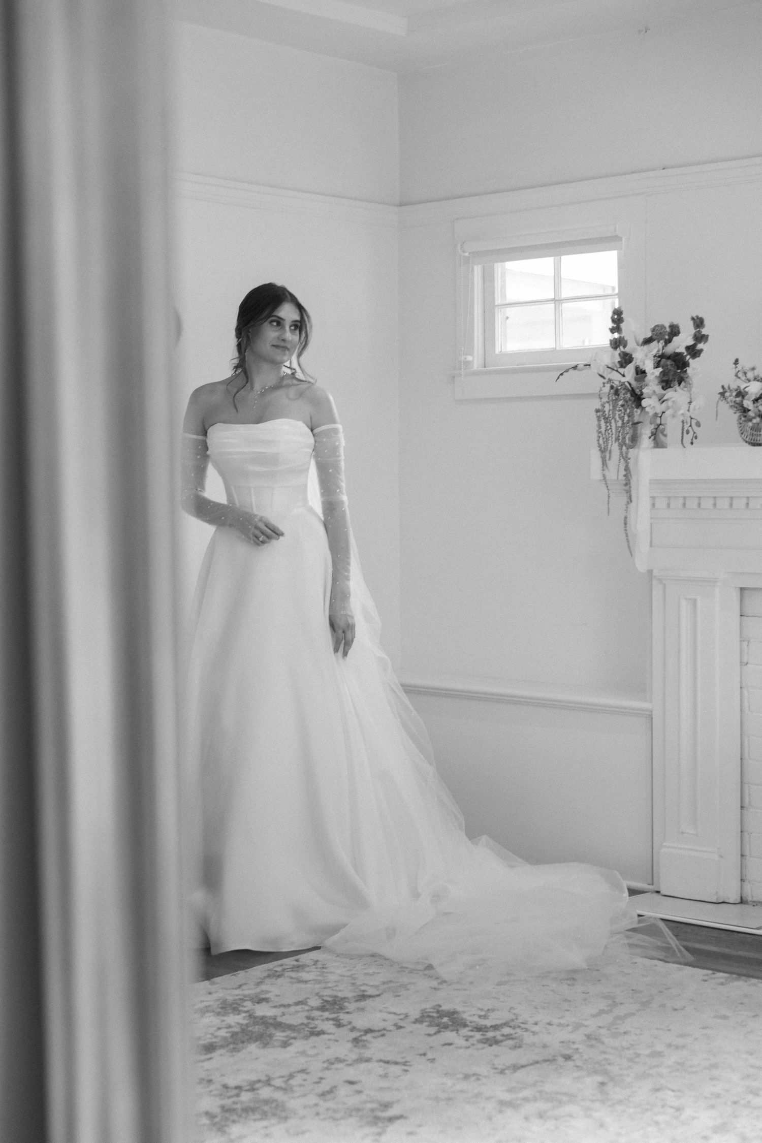 Classic black and white bridal portrait in minimalist room with fireplace.