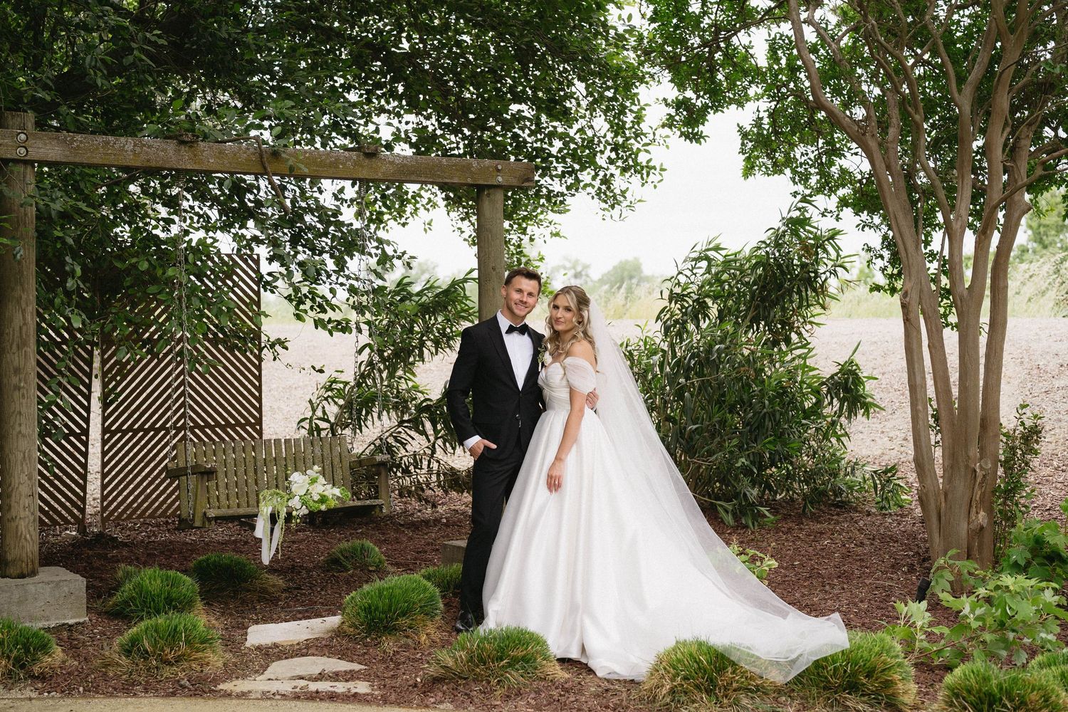 Romantic wedding portraits captured in a tree-lined garden setting.
