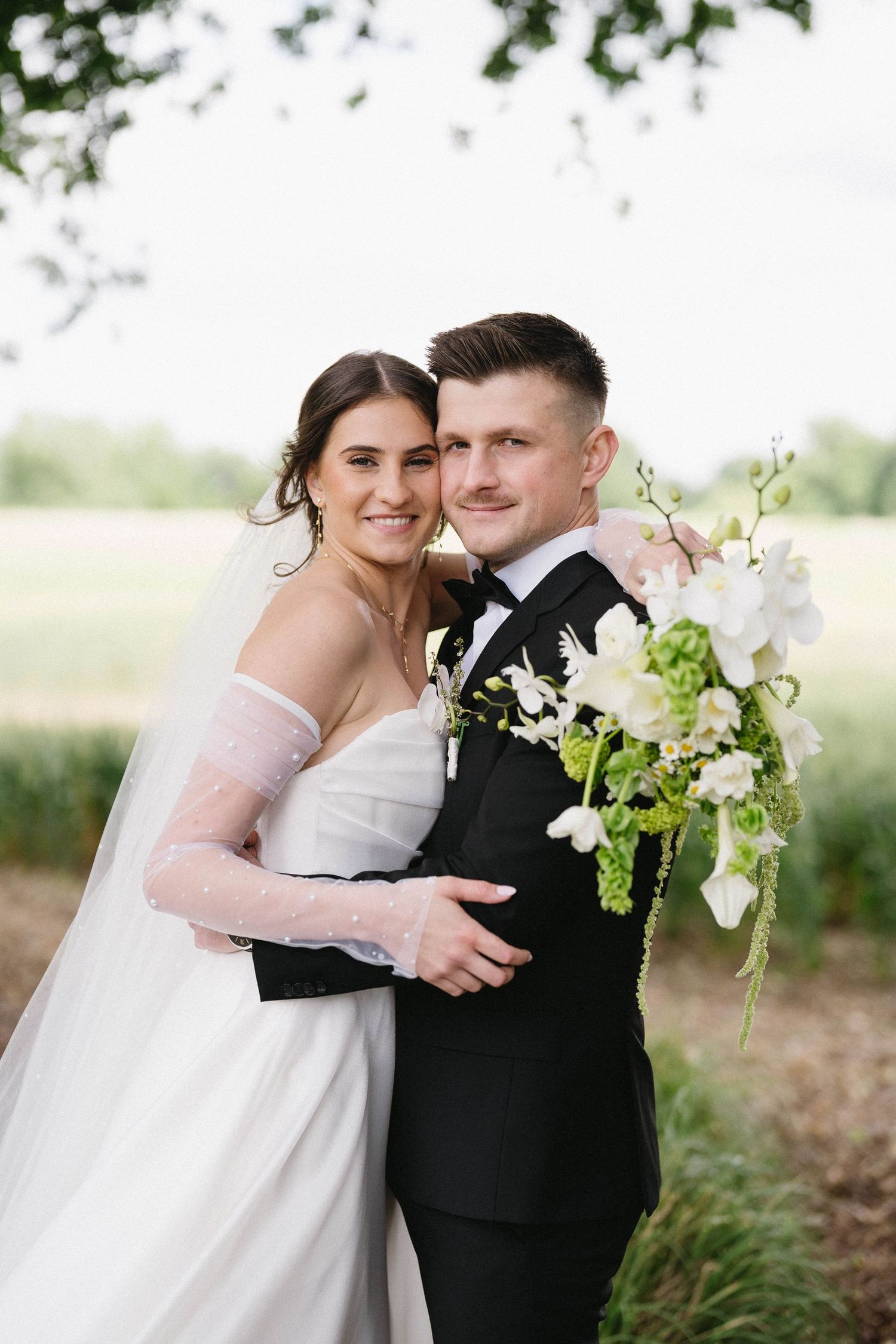 Romantic wedding portraits with white and green floral bouquet accents.