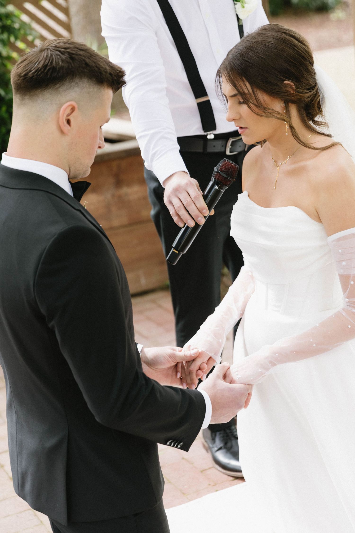 Close-up shots of a couple exchanging vows or notes during their wedding ceremony.