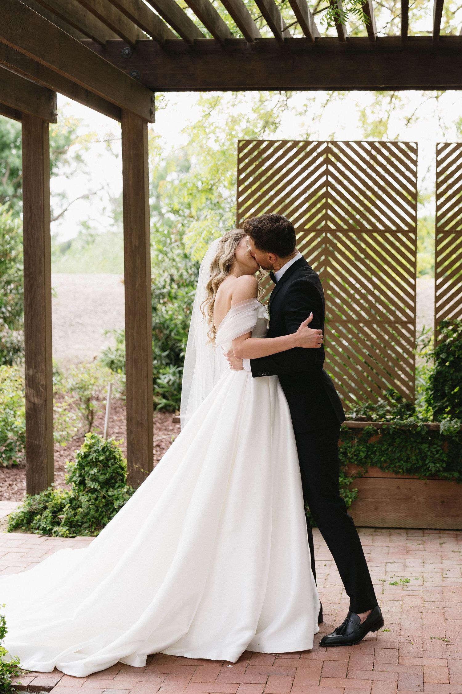 Intimate wedding moments captured under a wooden pergola with lattice details.