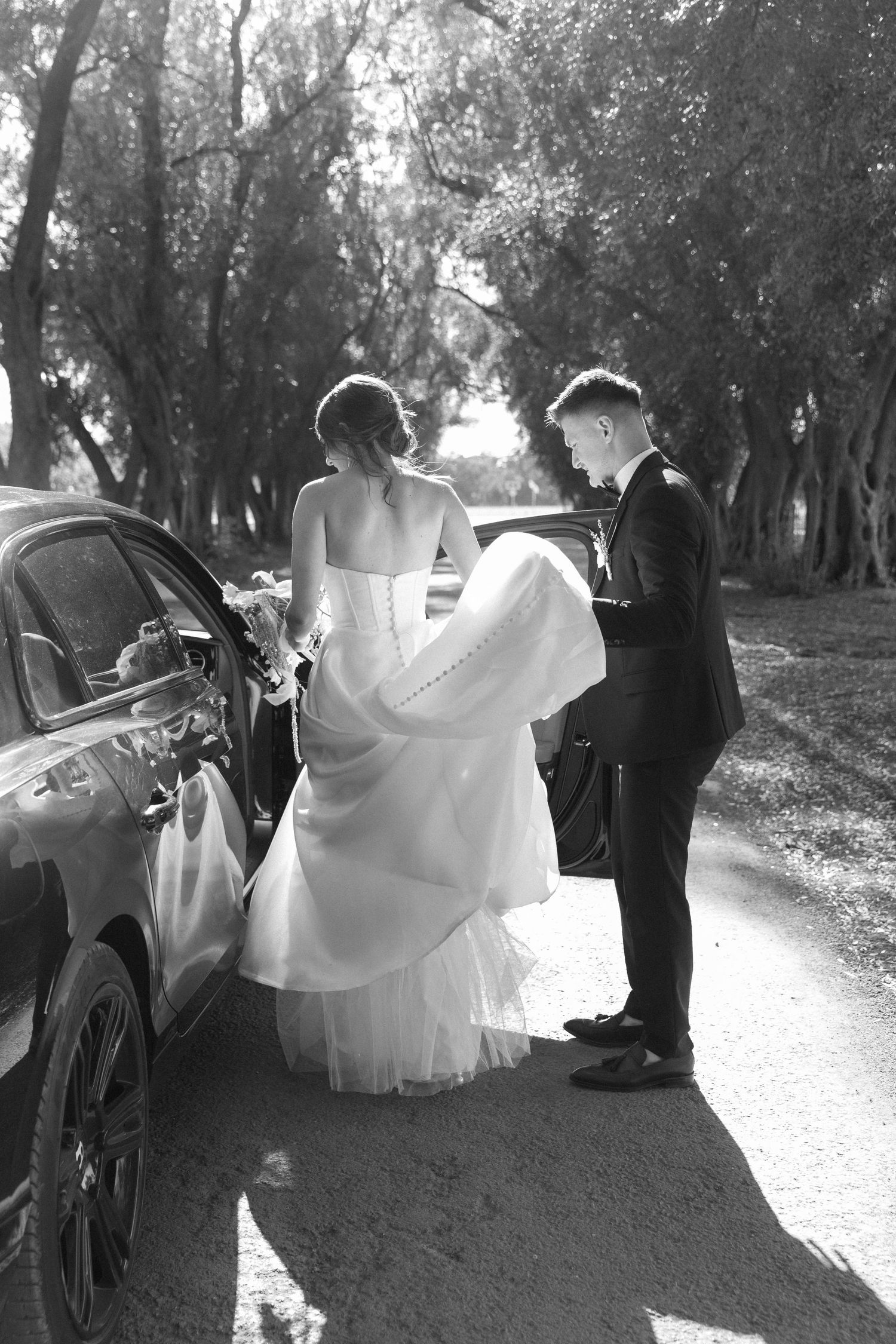 Black and white wedding sequence showing romantic moments on a tree-lined path.