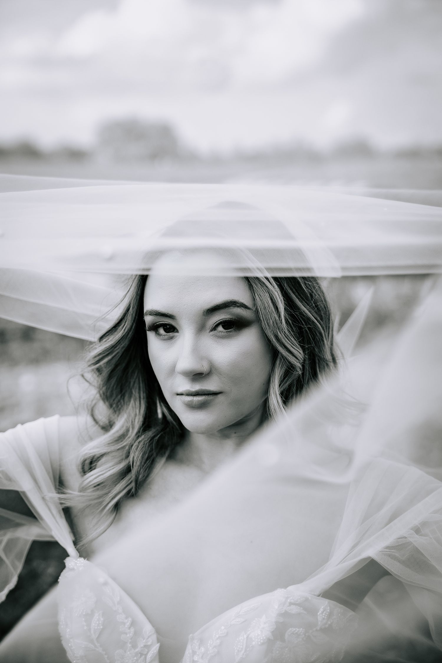 A soft black and white veil photo shoot featuring delicate flowing fabric creating an ethereal mood.