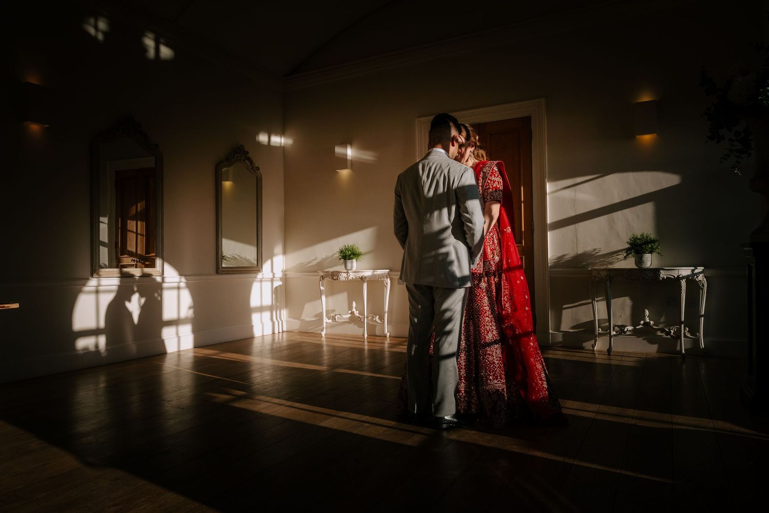 Artistic silhouettes in dramatic lighting create romantic shadows in an elegant indoor venue.