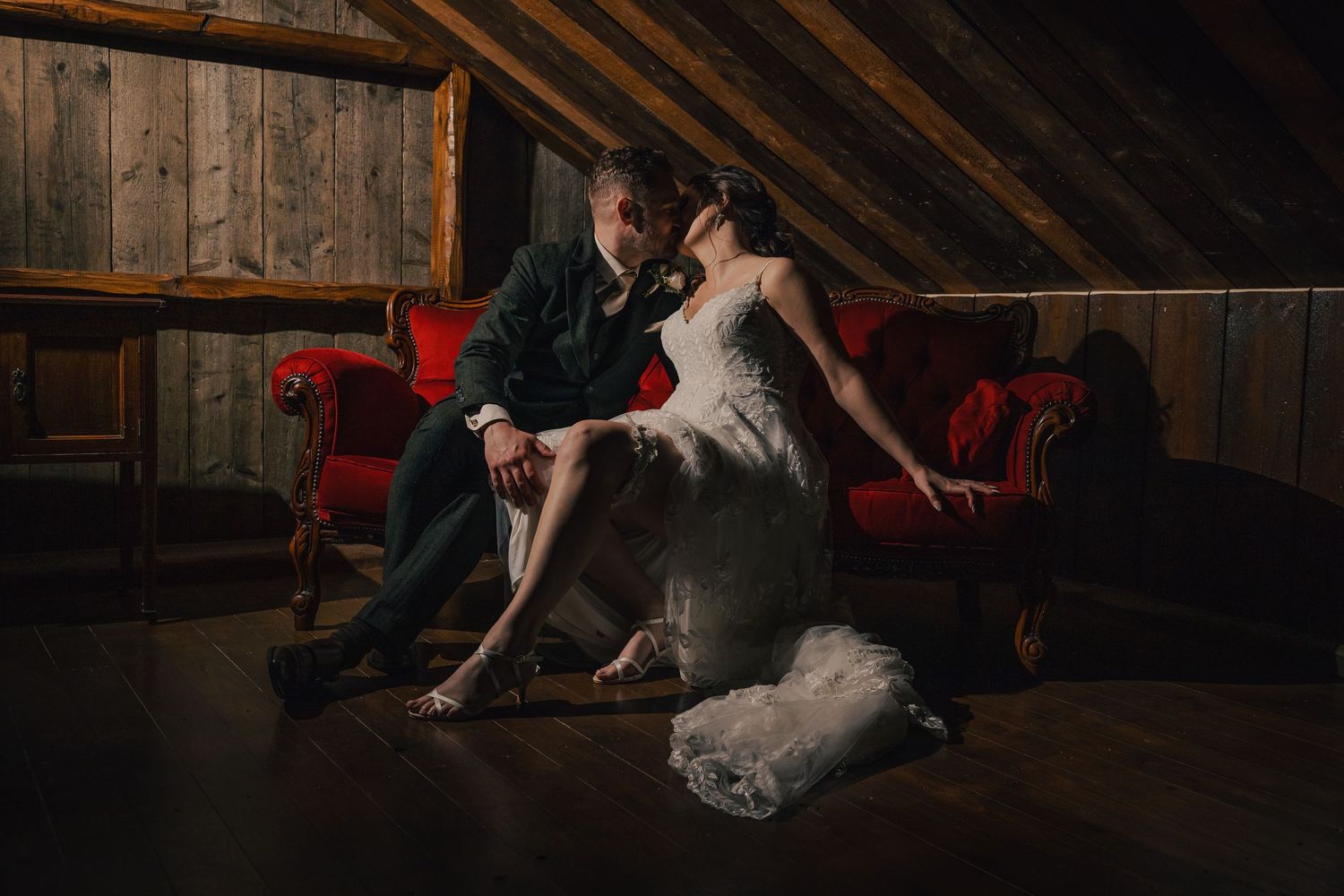 Dramatic indoor wedding photos with moody lighting in a rustic wooden interior.
