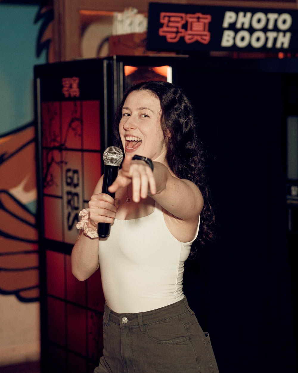 candid photo of a woman pointing to the camera during a nightlife party in sydney by sam haber