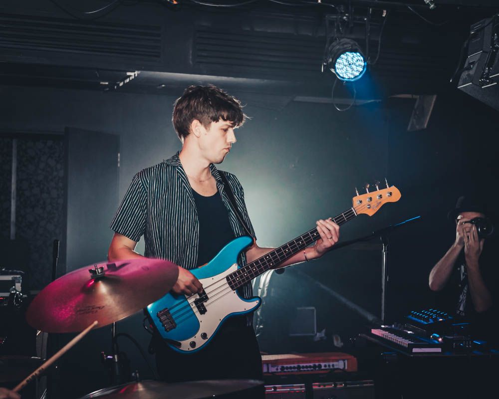 candid photo of a man with a guitar during nightlife party in sydney by sam haber