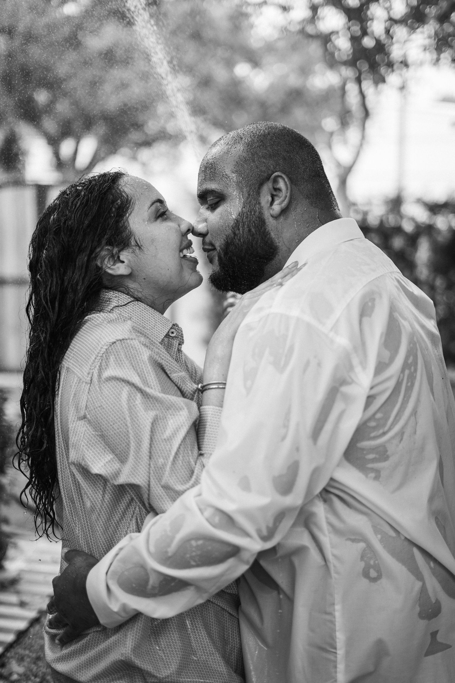 Series of intimate black and white photos showing tender moments between a couple in white clothing.