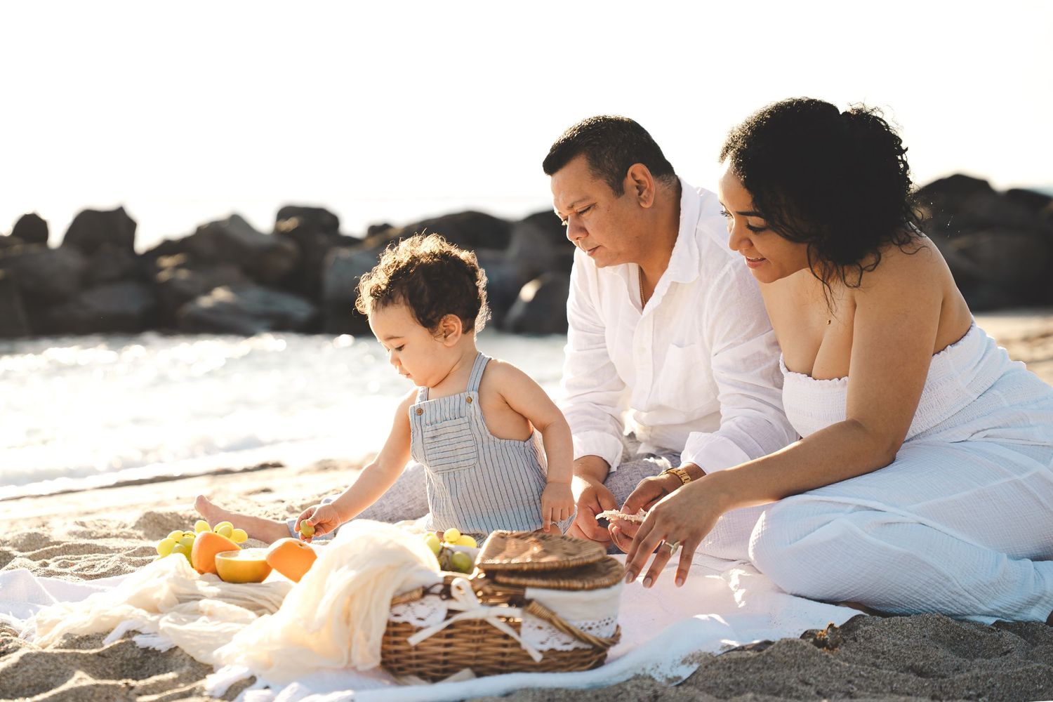 Family sharing intimate moments during sunset beach picnic.