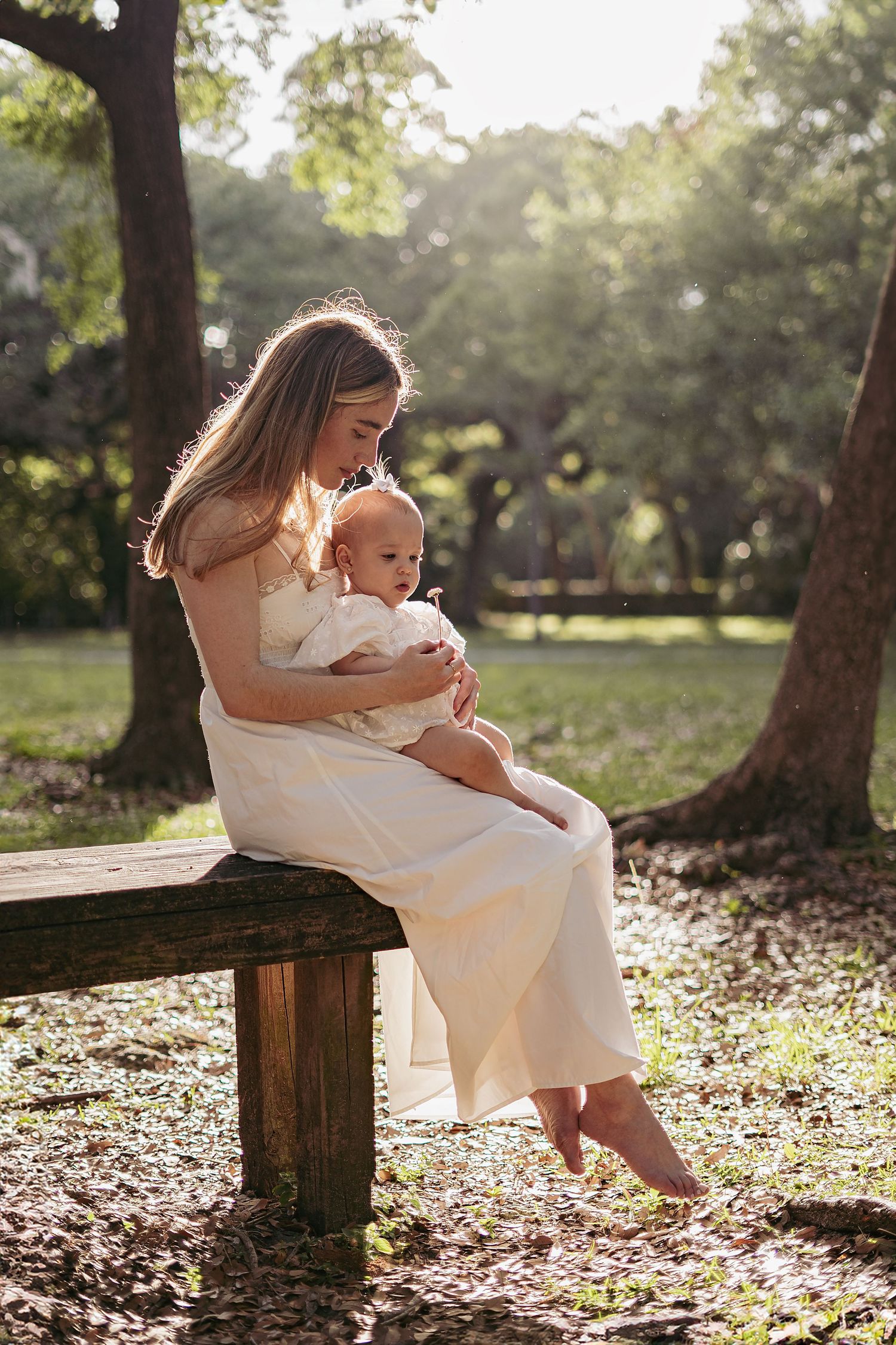 Mother and child sharing tender moments on a wooden bench in a park.