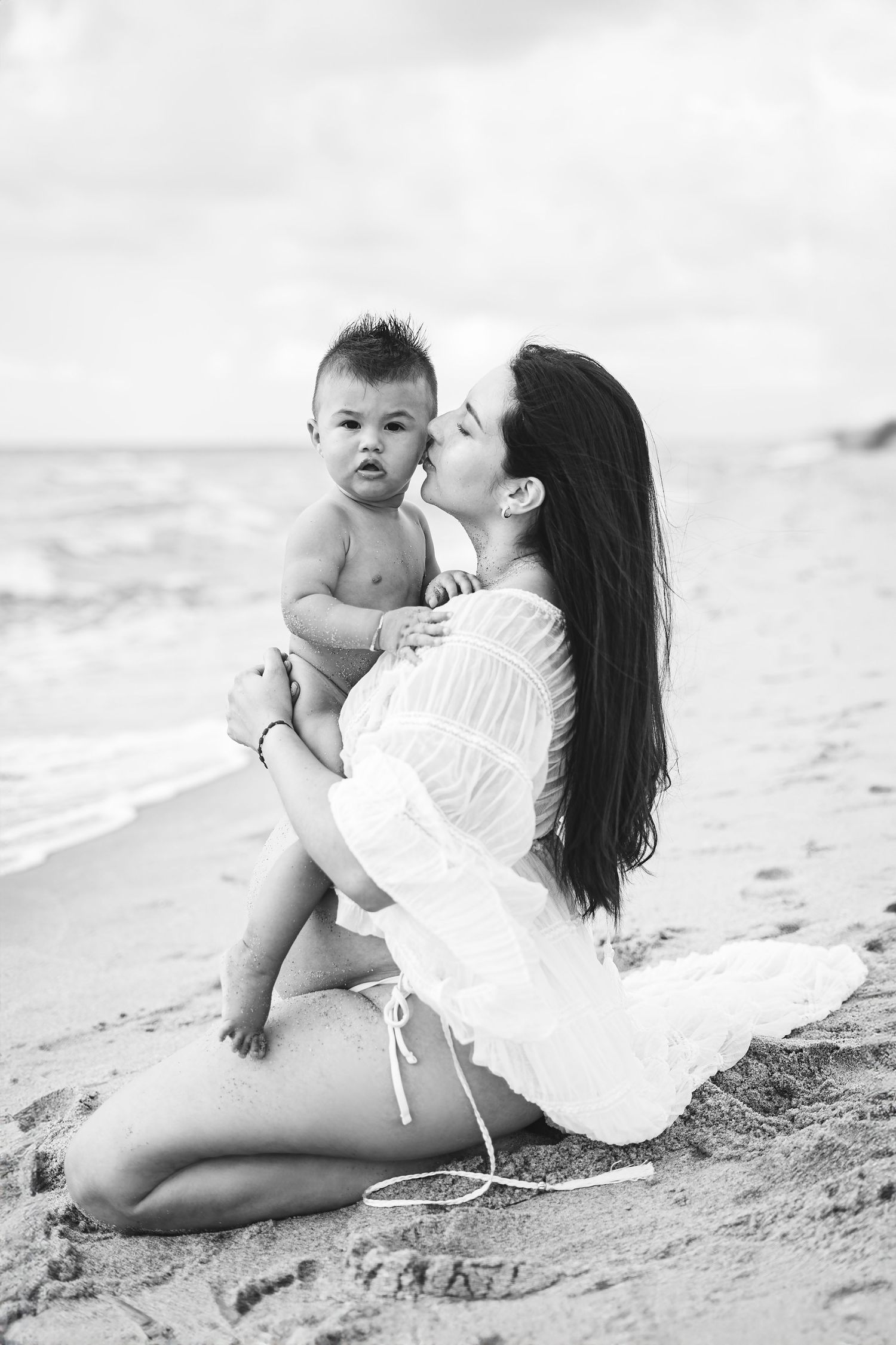 Intimate black and white beach photography session with soft natural lighting.