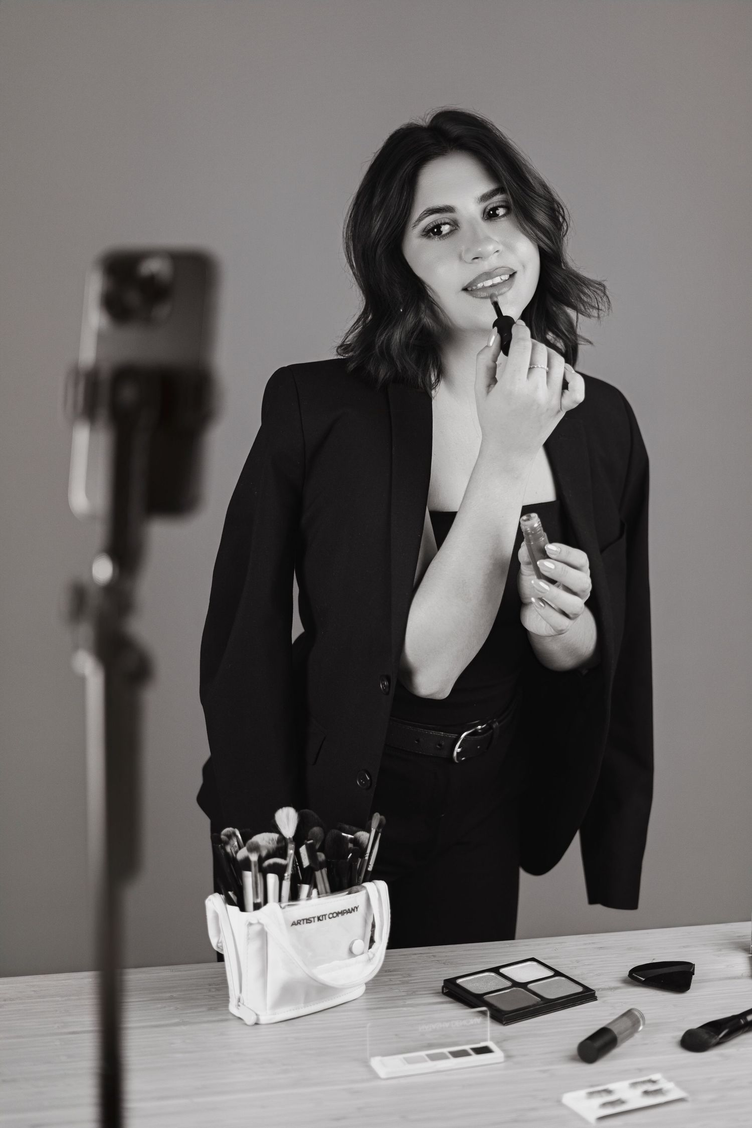 Black and white photo series showing makeup application in professional setting.