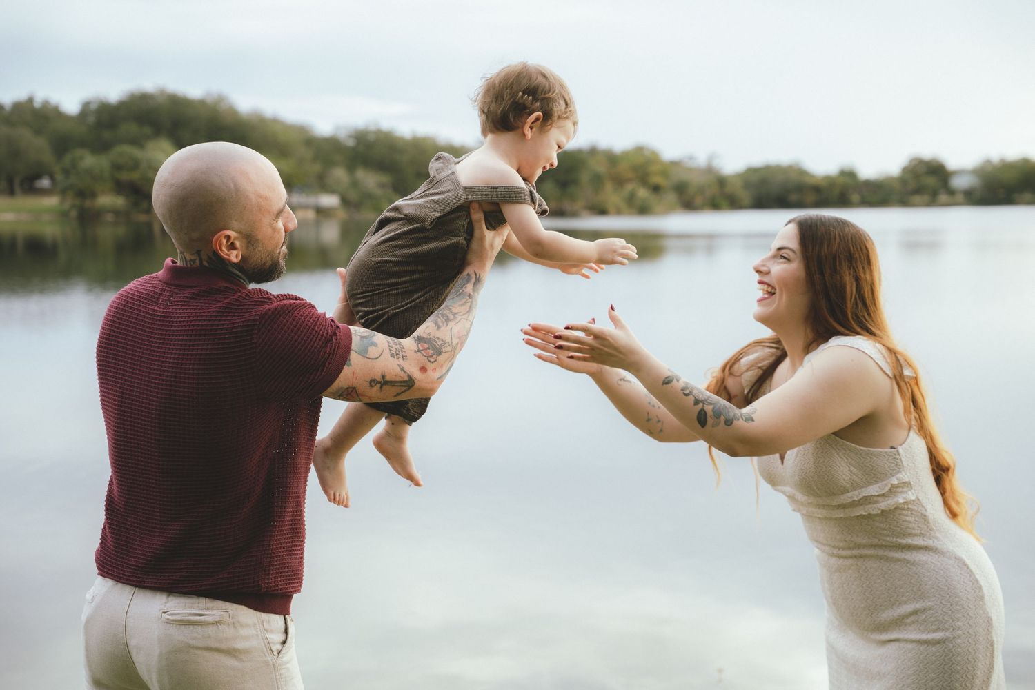 Playful family moment captured by a lake with movement and laughter.