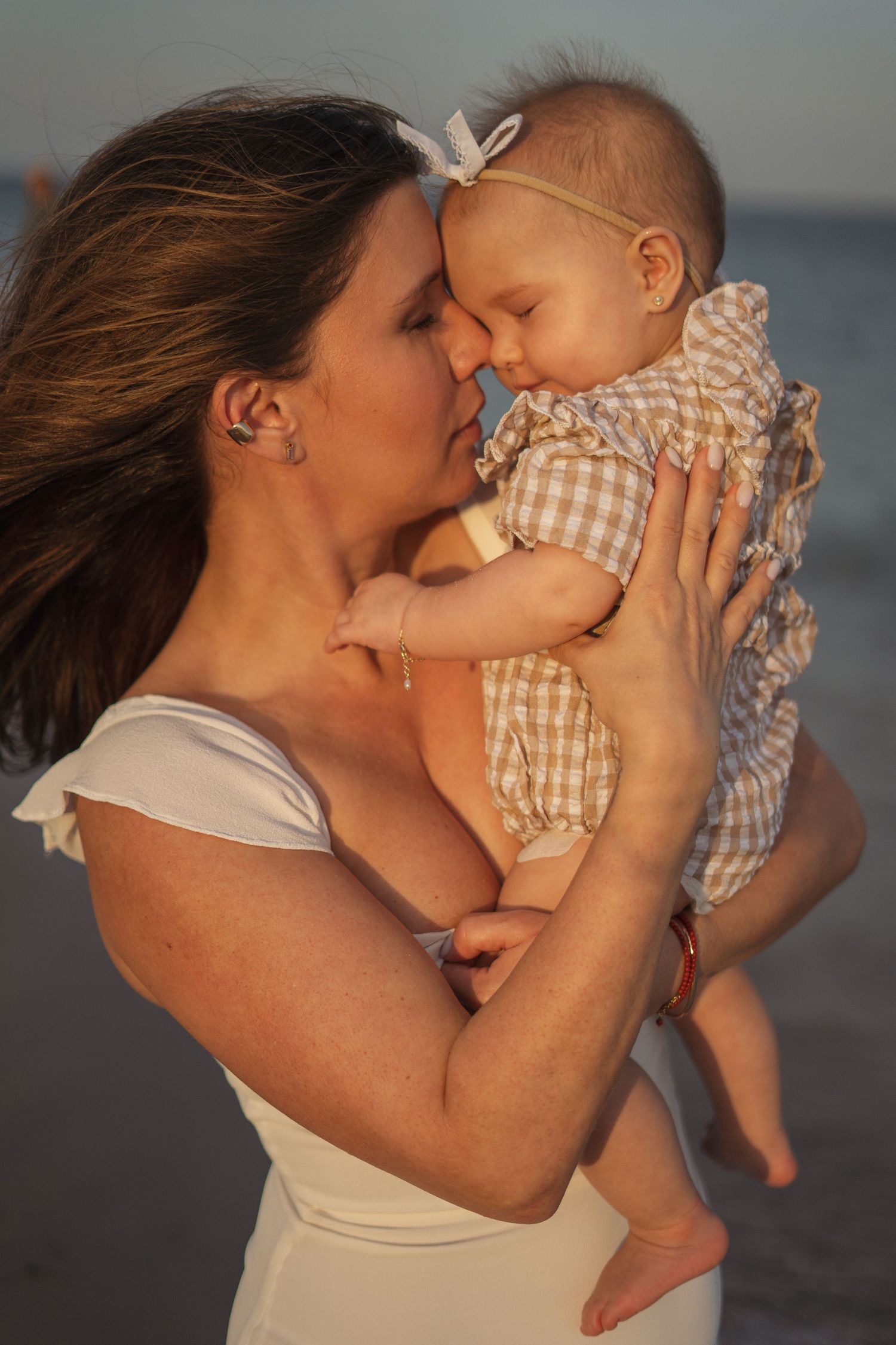 Golden hour beach photography with soft lighting and gentle embraces.