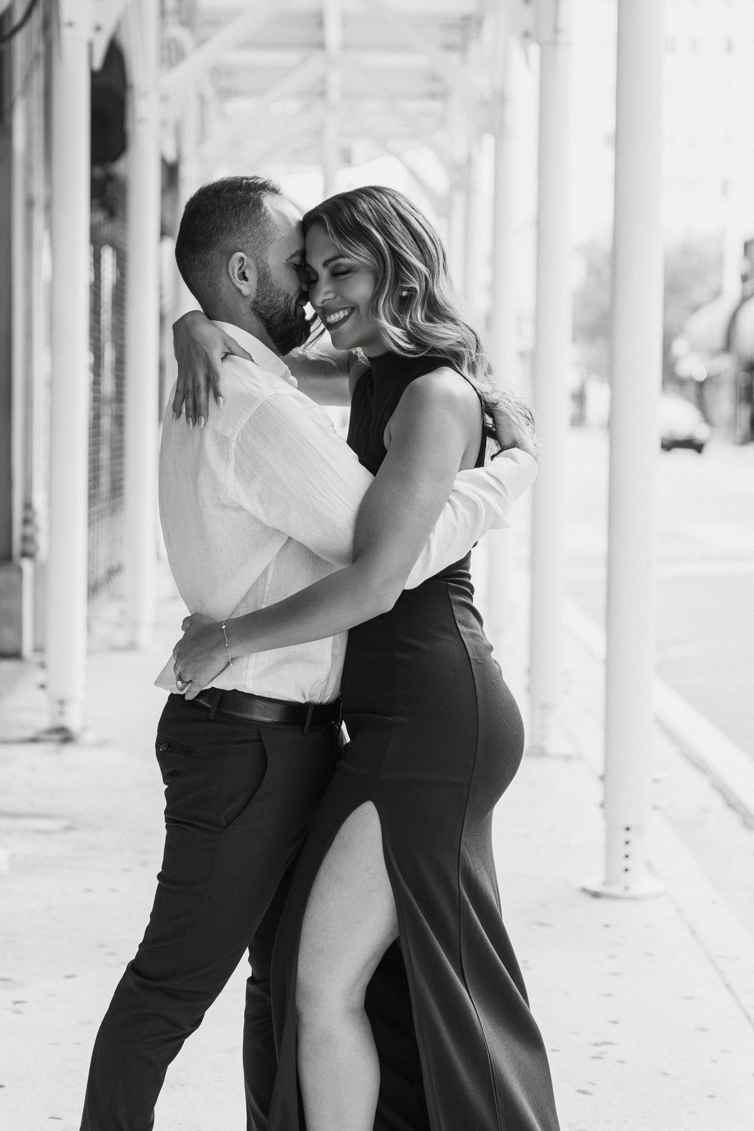 Romantic black and white portrait of a couple embracing in formal wear.