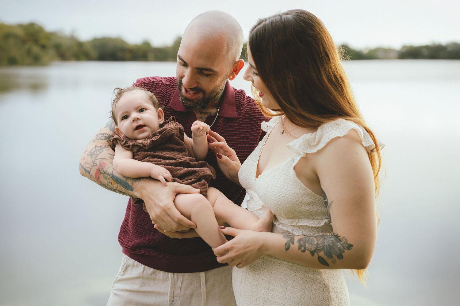 A family shares an intimate moment by a lake during a photo session.
