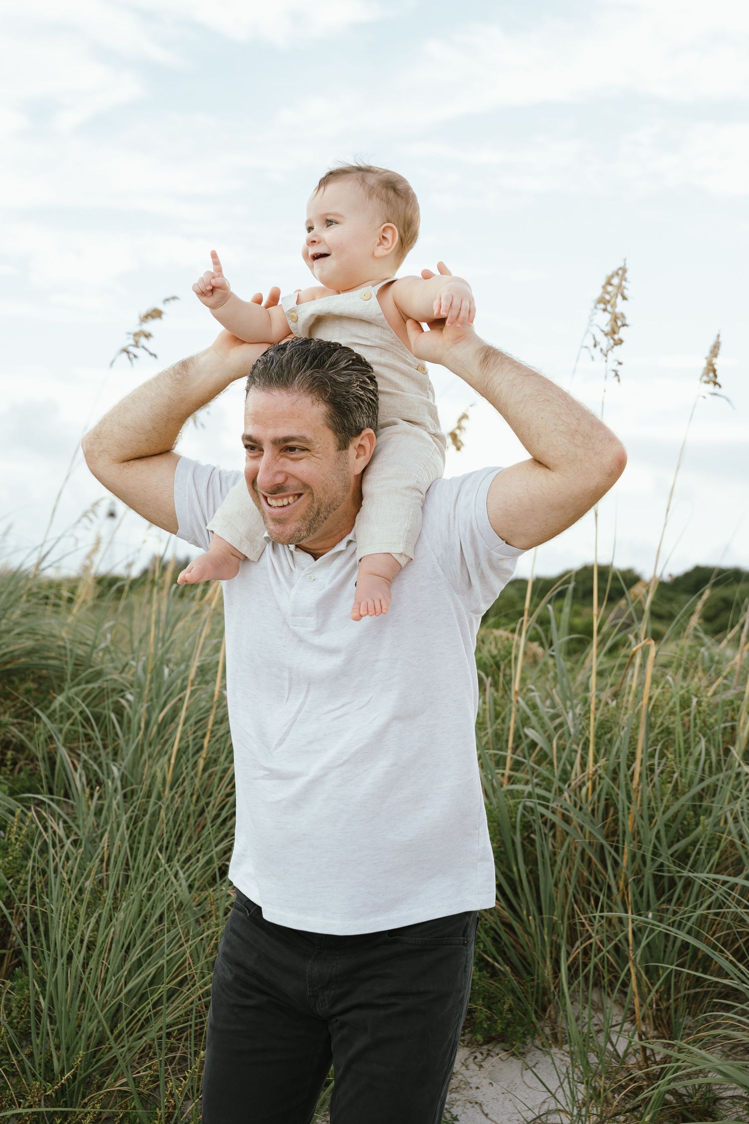 Joyful outdoor photos in tall grass with white shirt and natural lighting.