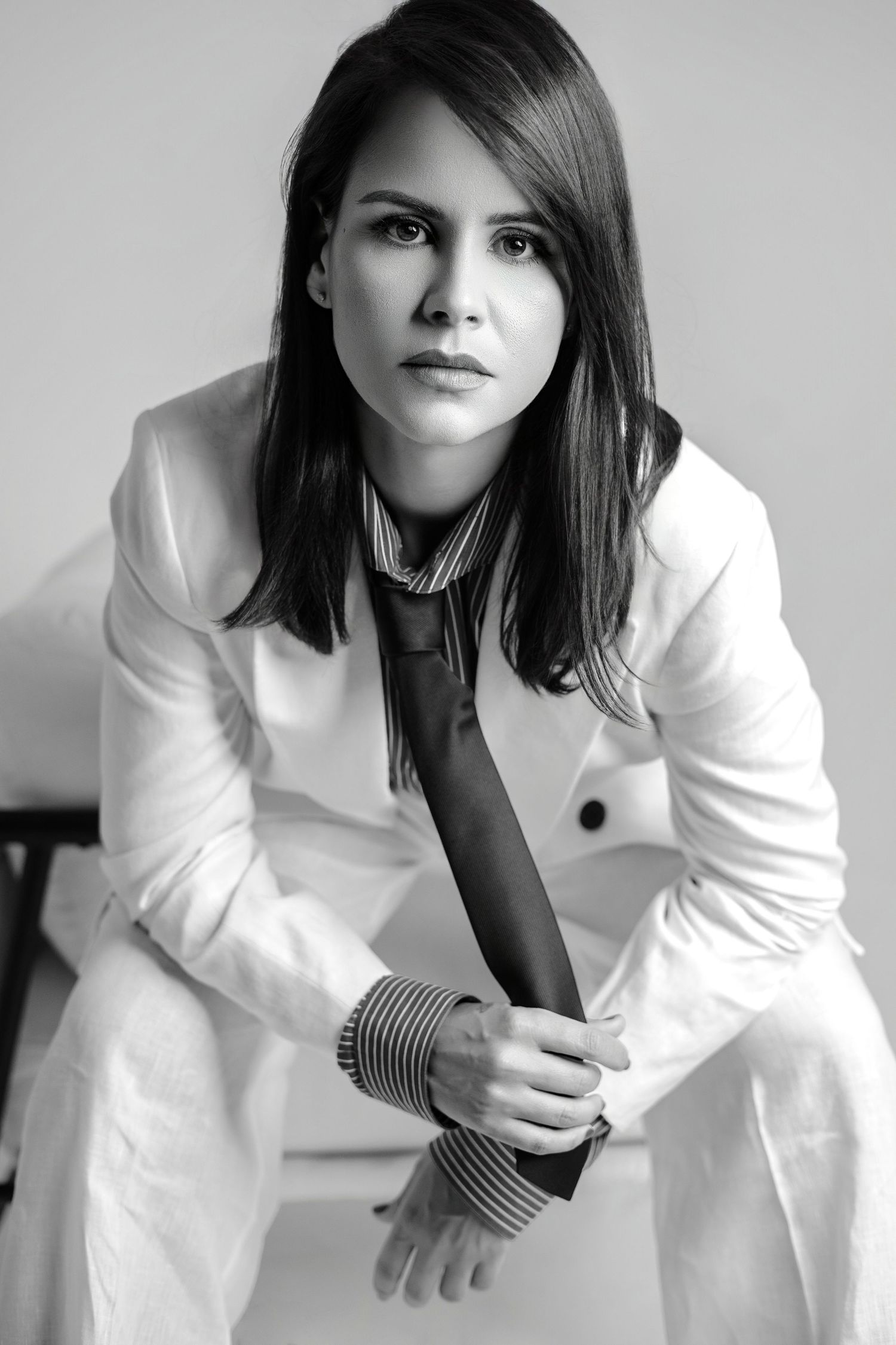 Black and white portrait series in white blazer showing professional poses.