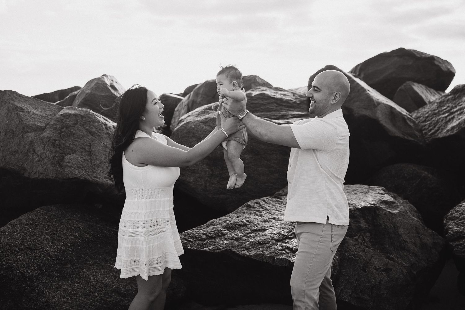 Black and white photos show tender family moments at a beach picnic.