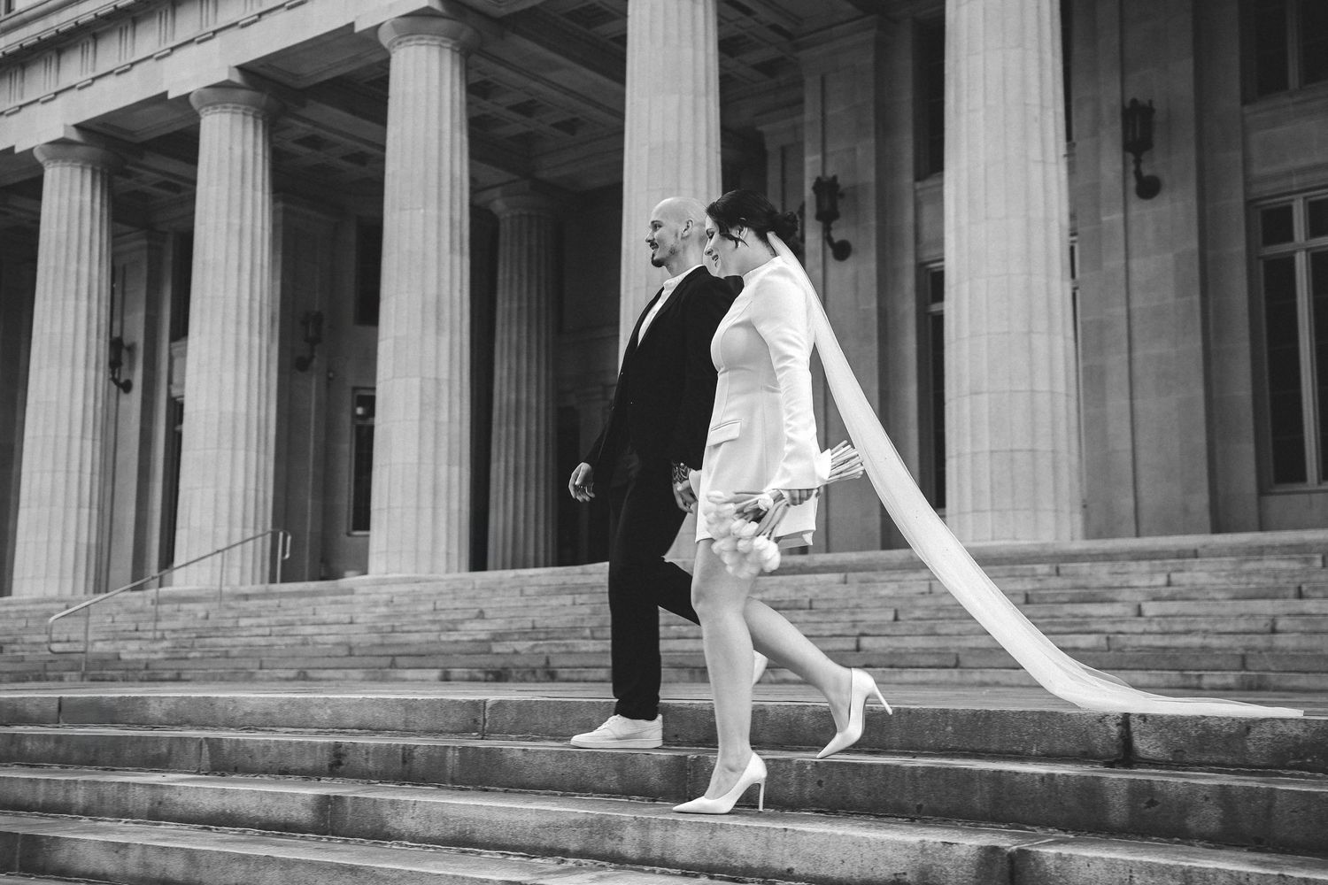 Architectural detail of classical columns and stone steps in black and white.