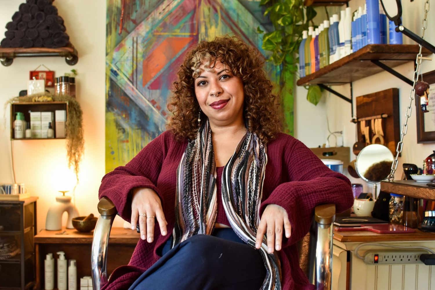 A person smiles while sitting in multiple poses at a warm cafe interior with soft lighting and rustic decor.
