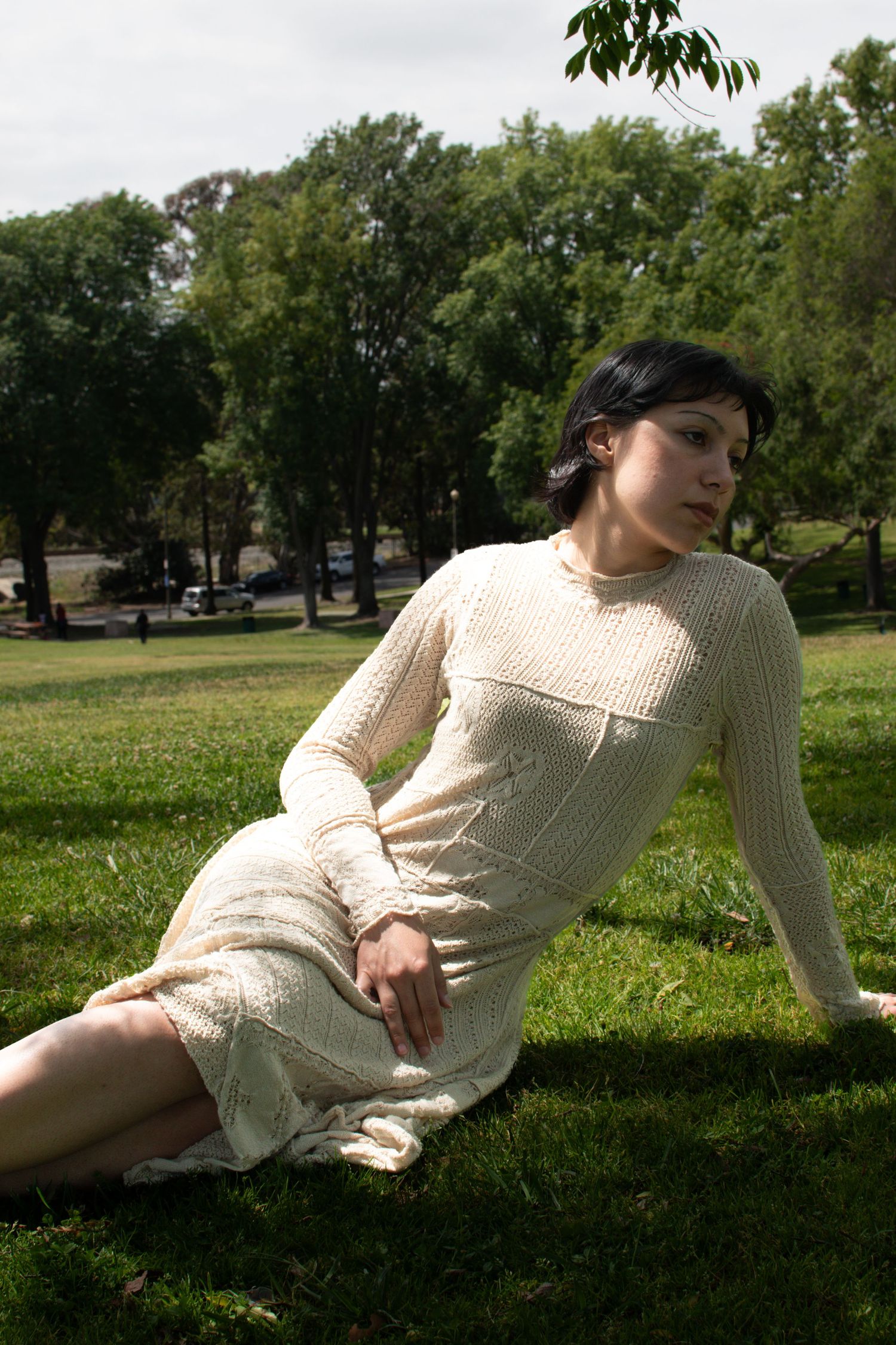 Elegant cream knit dress photographed in natural park lighting.