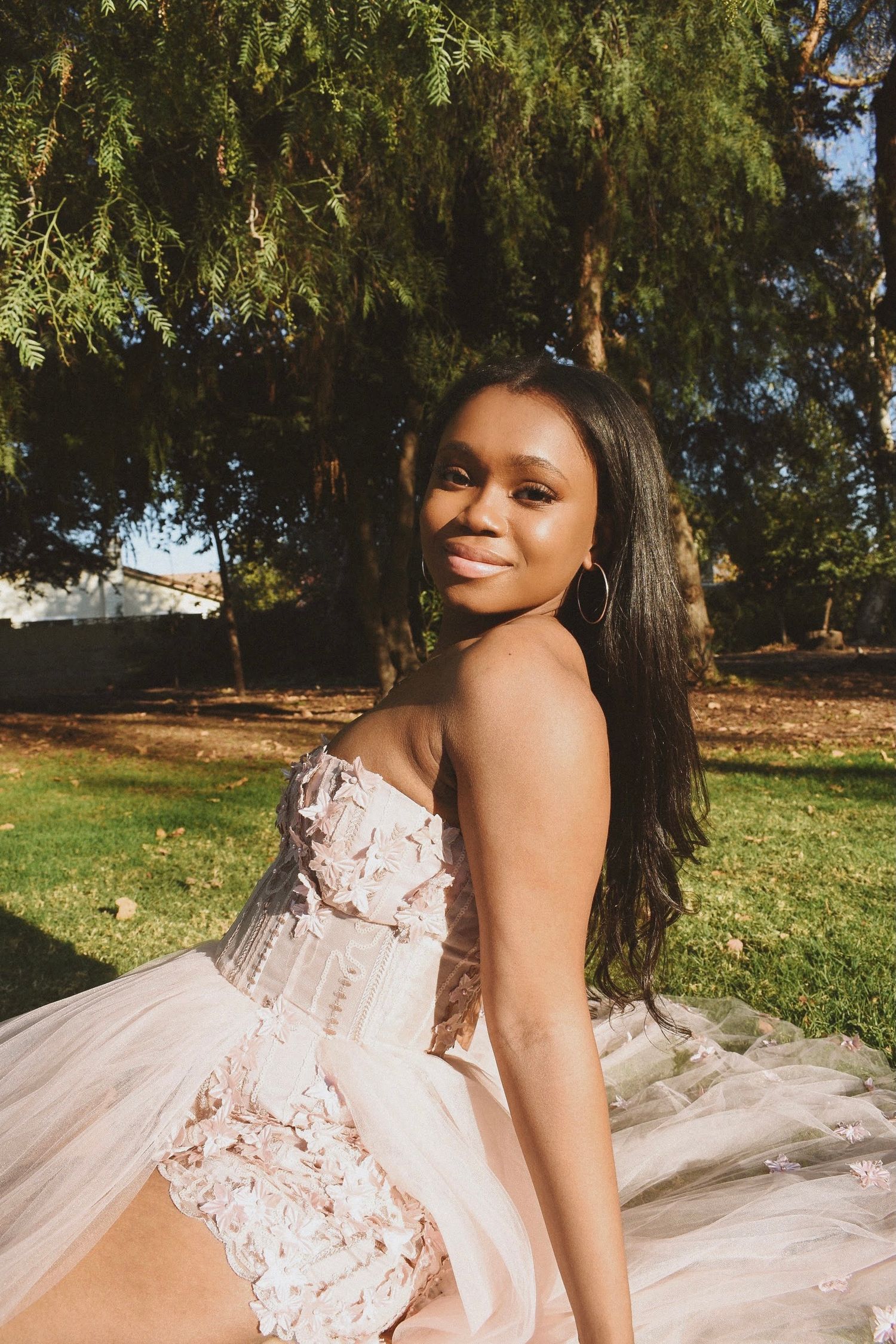 A romantic outdoor photoshoot featuring a blush-colored tulle gown with detailed bodice.