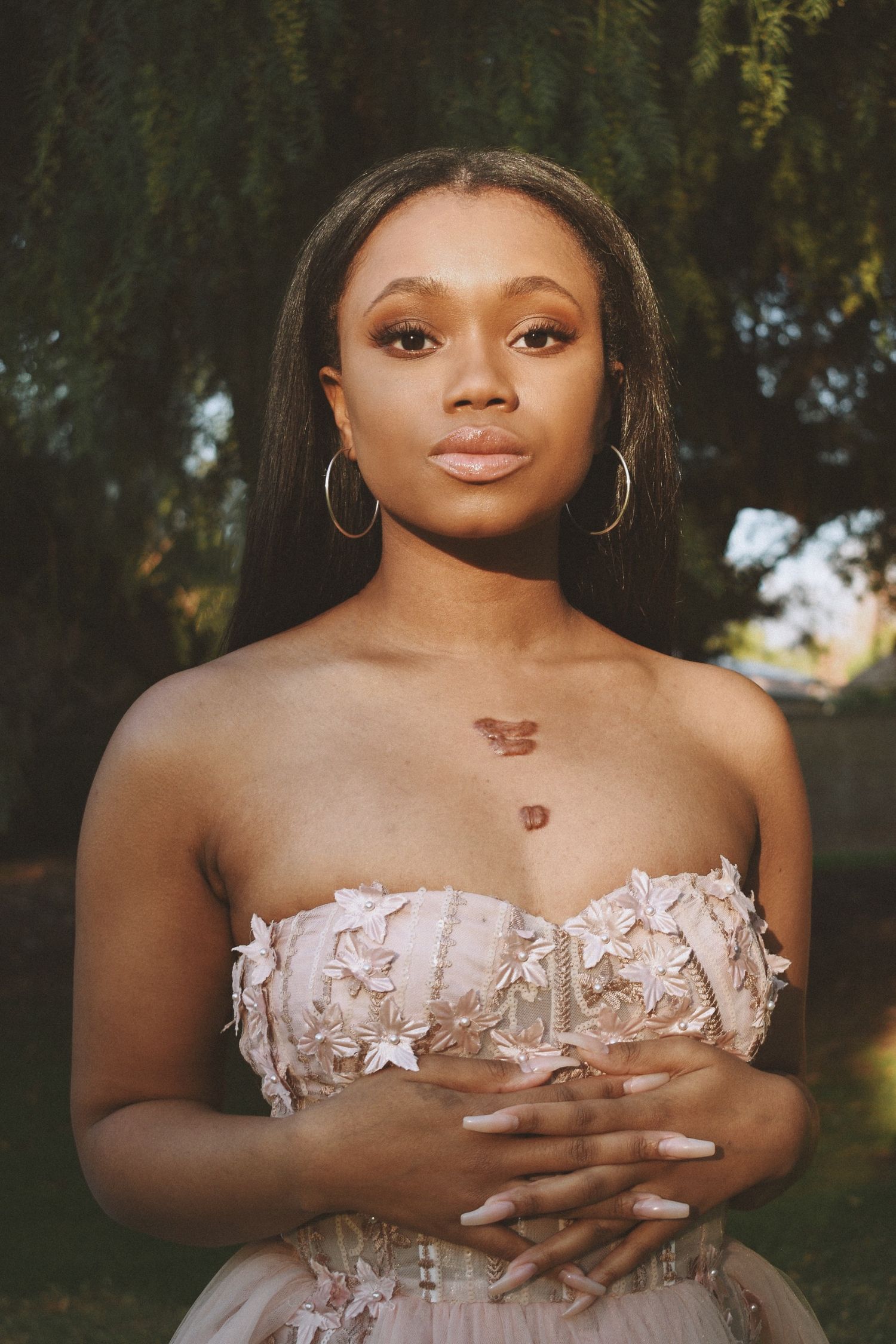 A close-up portrait showcasing a strapless blush gown with intricate lace detailing.