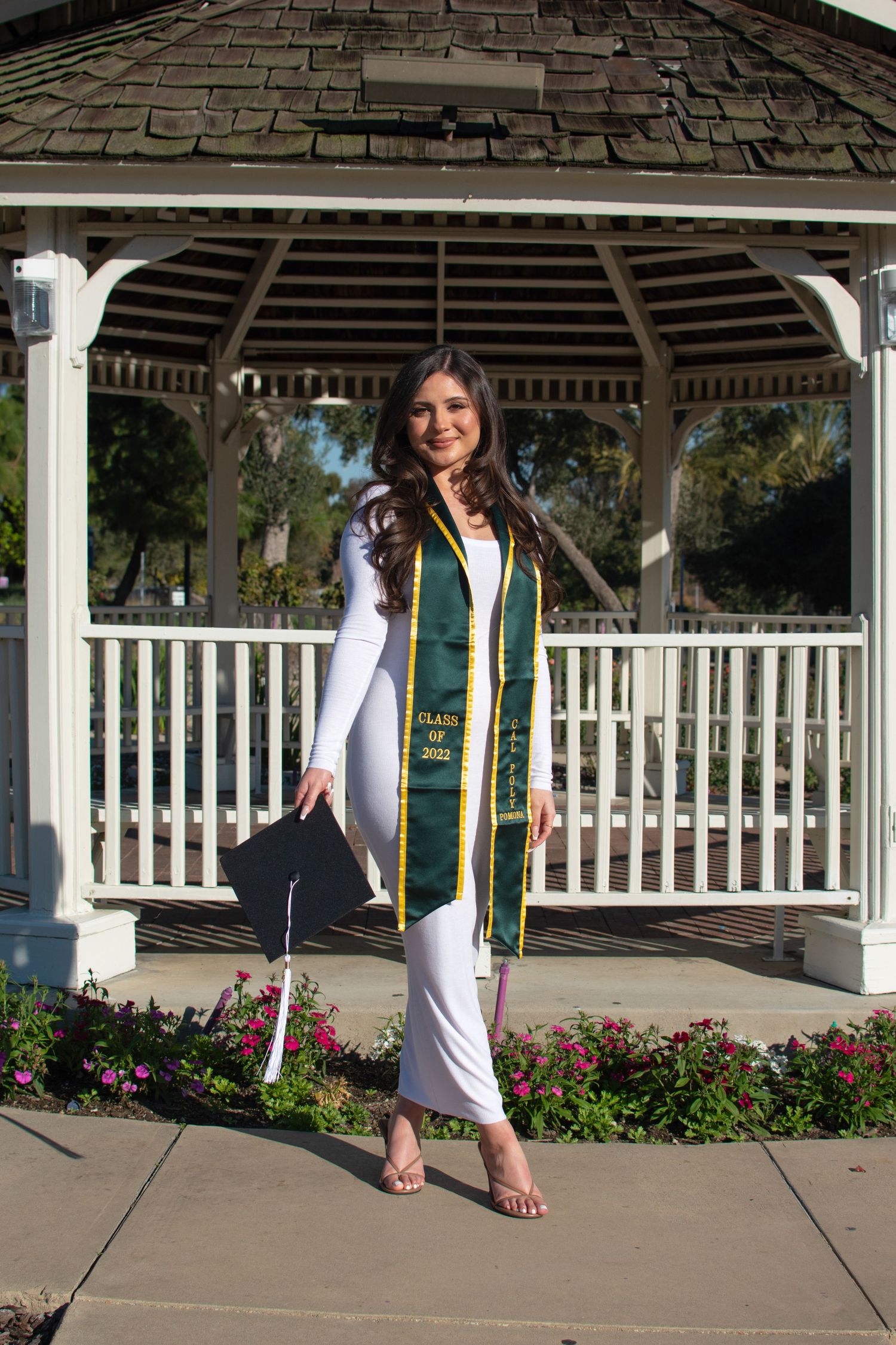 Graduation portrait series in white gazebo showing full length poses with green and gold stole.