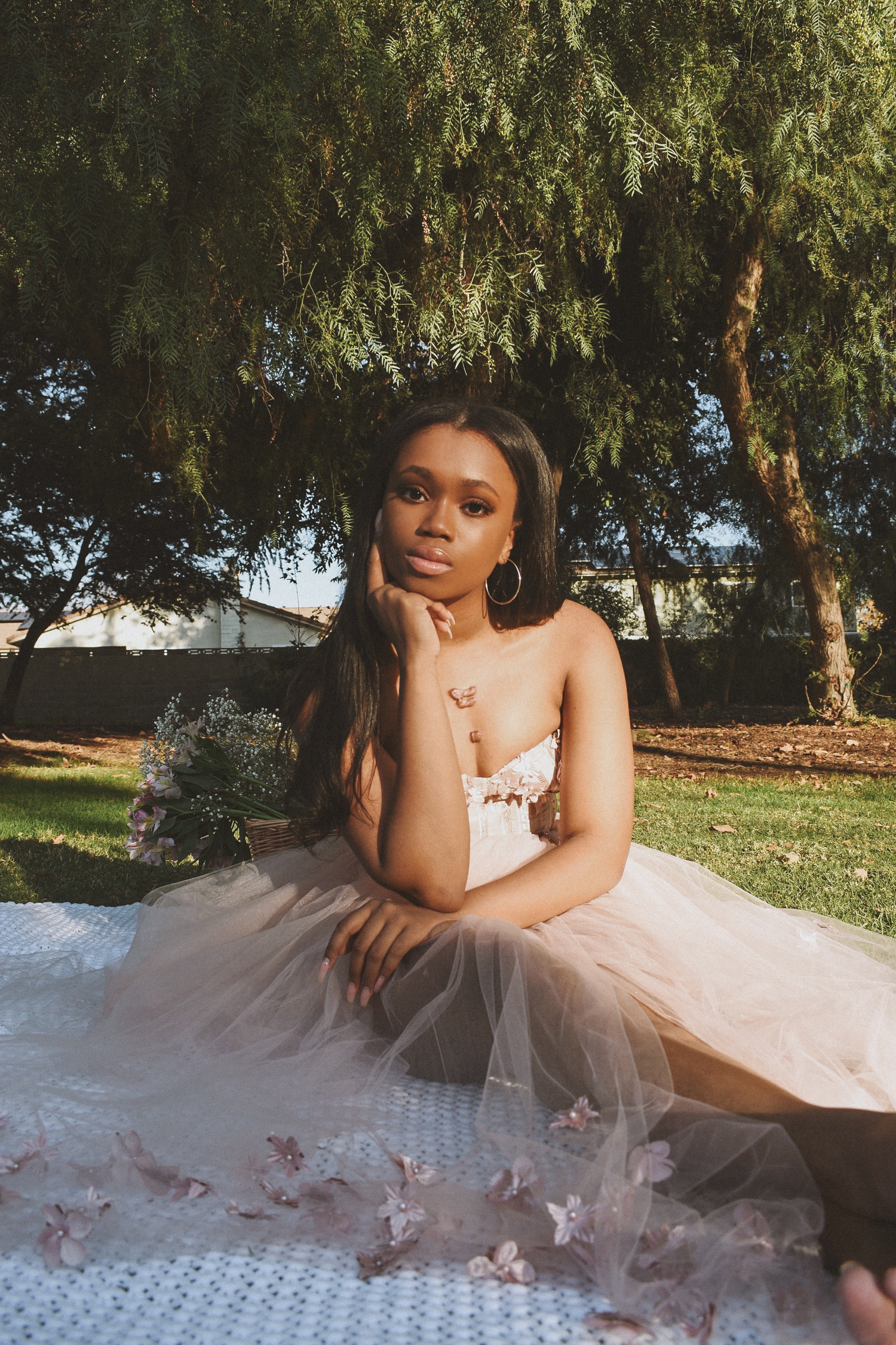 A dreamy outdoor portrait with a tulle dress and willow trees creating a romantic backdrop.