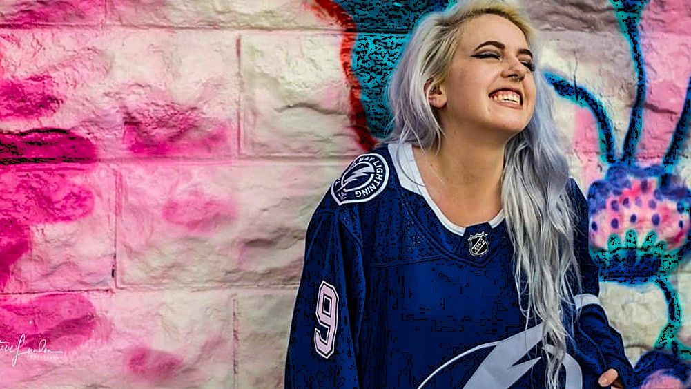 portrait of a young woman in a hockey jersey laughig
