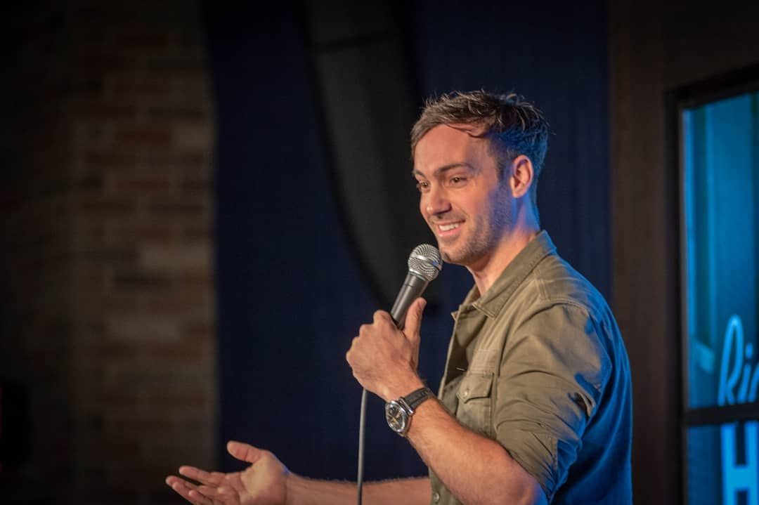 male comedian on stage laughing