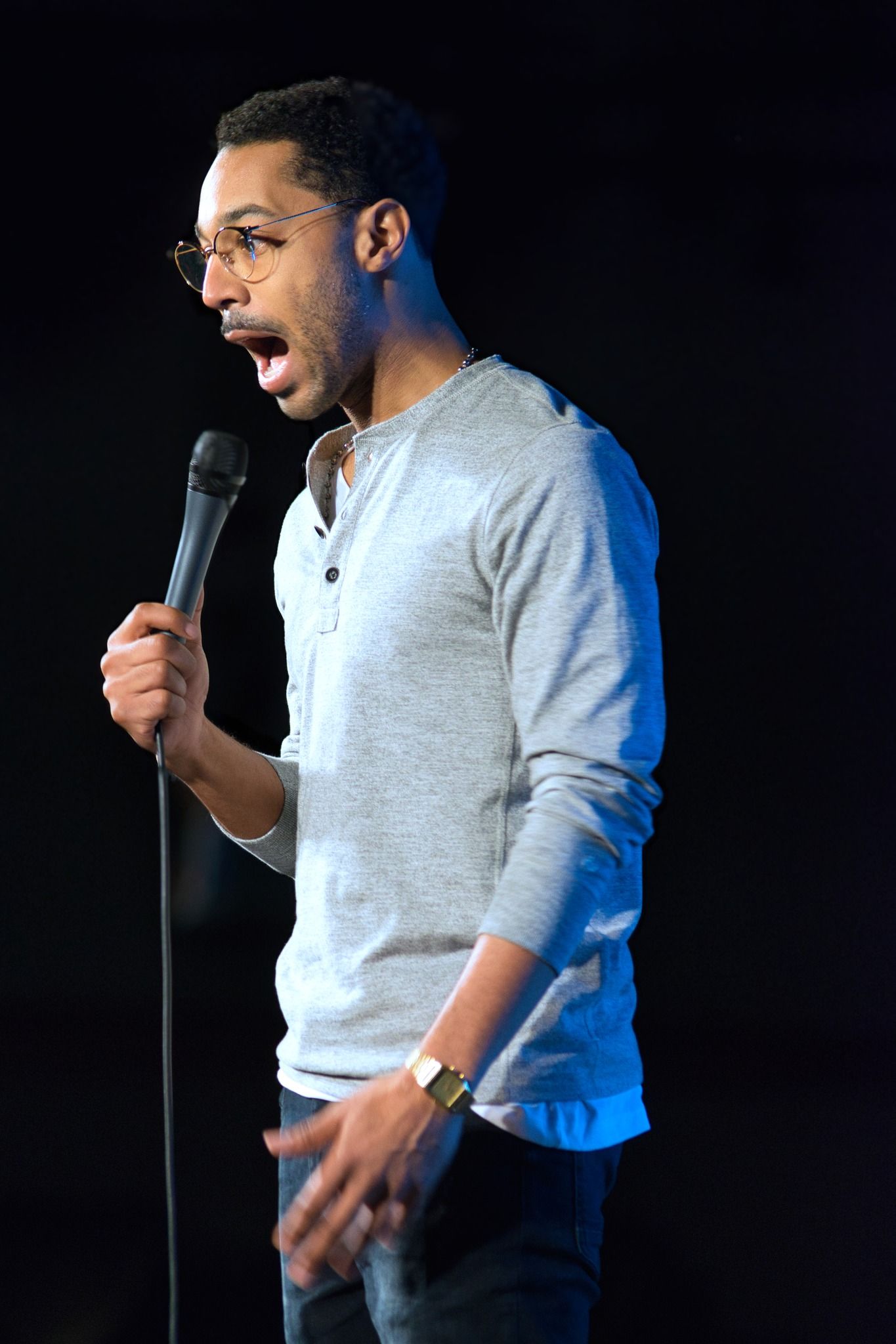 male comedian on stage making a funny face
