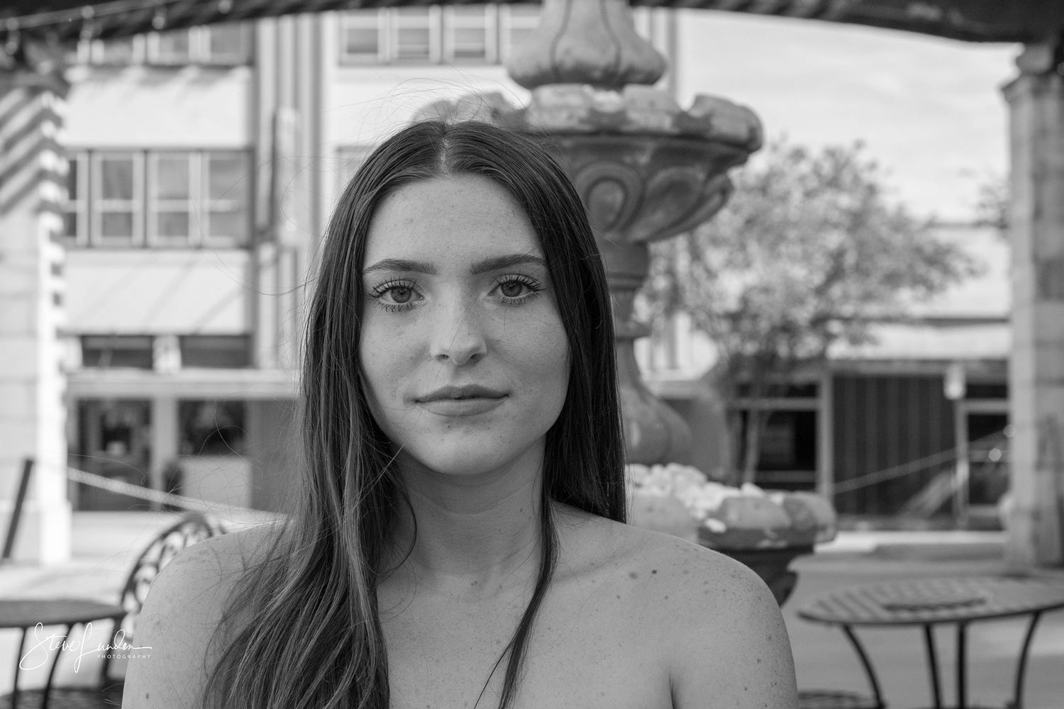 photo of young woman in front of a water fountain
